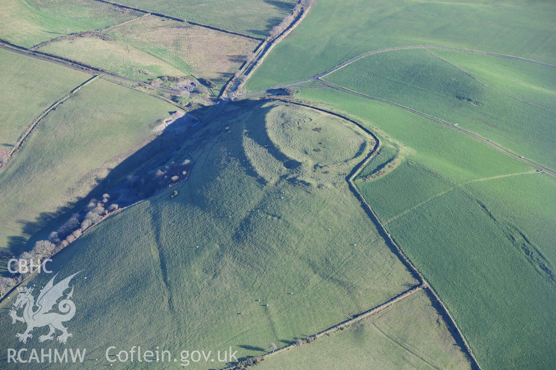 Oblique aerial photograph of Castell Perthi Mawr, with earthworks of prehistoric fields to the north west. Taken during the Royal Commission’s programme of archaeological aerial reconnaissance by Toby Driver on 17th January 2022