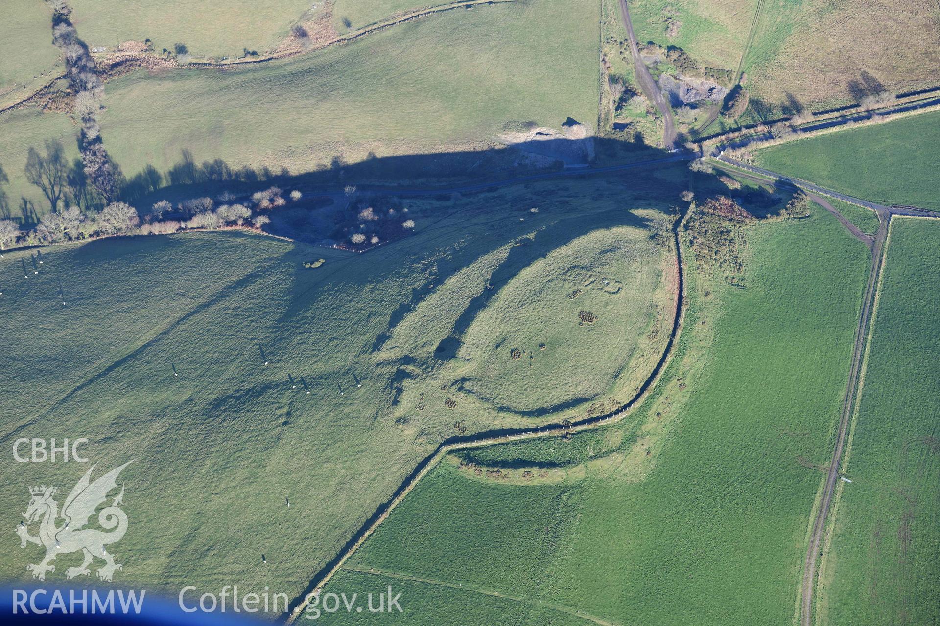 Oblique aerial photograph of Castell Perthi Mawr, with earthworks of prehistoric fields to the north west. Taken during the Royal Commission’s programme of archaeological aerial reconnaissance by Toby Driver on 17th January 2022