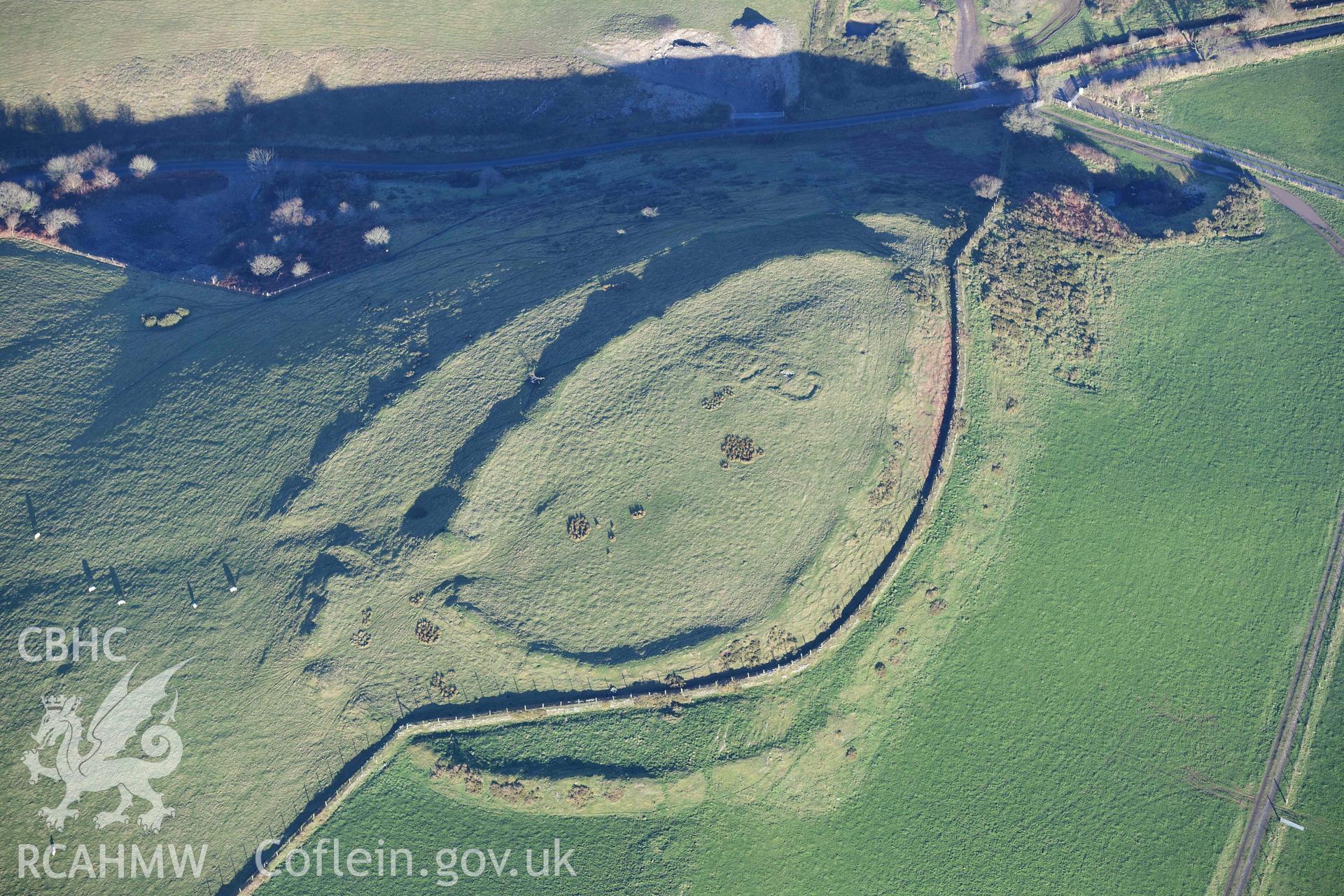 Oblique aerial photograph of Castell Perthi Mawr, with earthworks of prehistoric fields to the north west. Taken during the Royal Commission’s programme of archaeological aerial reconnaissance by Toby Driver on 17th January 2022