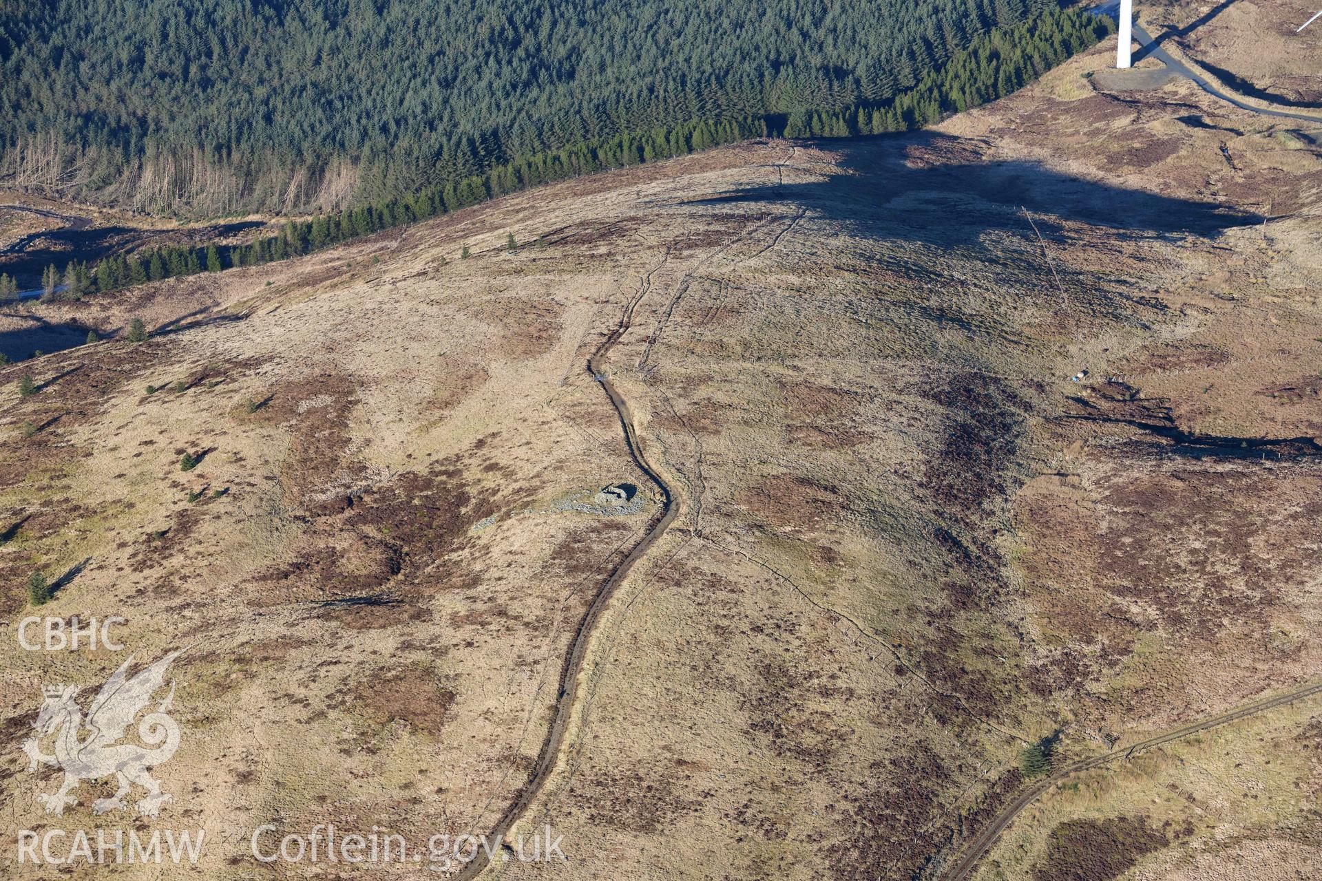 Oblique aerial photograph of Pen y Garn round cairn taken during the Royal Commission’s programme of archaeological aerial reconnaissance by Toby Driver on 17th January 2022