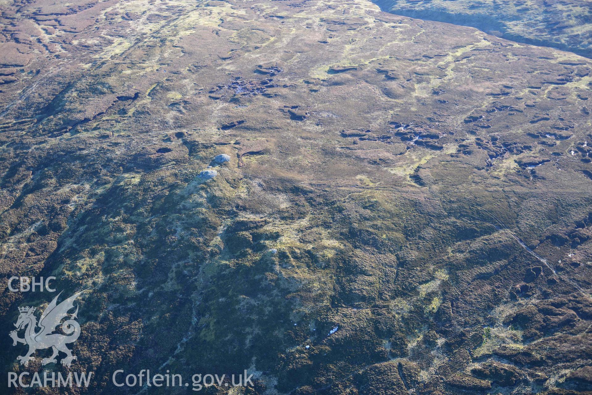 Oblique aerial photograph of cairn pair and outlier at Cairn Biga cairn taken during the Royal Commission’s programme of archaeological aerial reconnaissance by Toby Driver on 17th January 2022