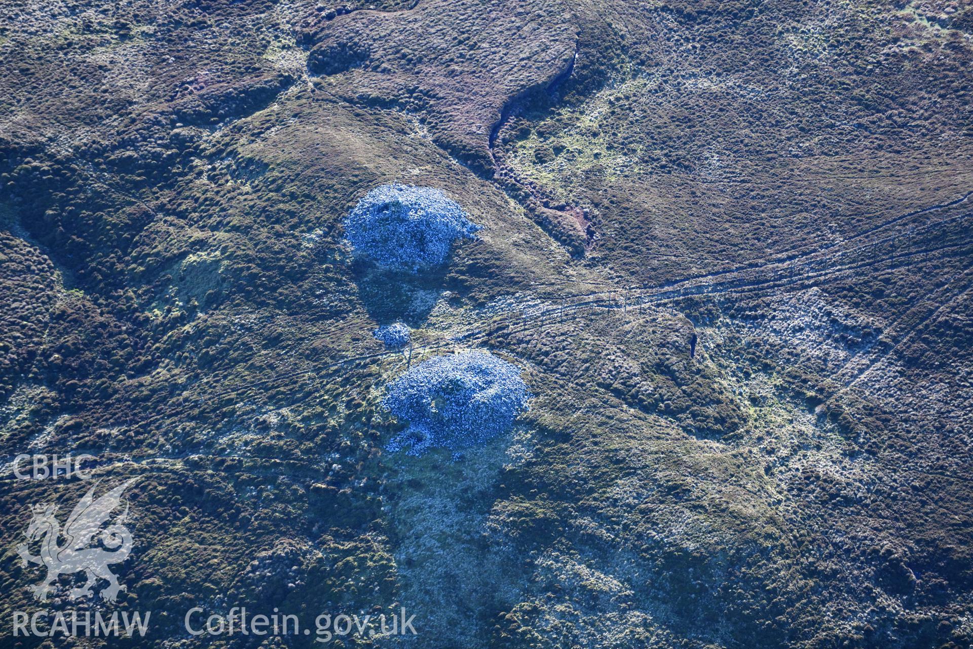 Oblique aerial photograph of cairn pair and outlier at Cairn Biga cairn taken during the Royal Commission’s programme of archaeological aerial reconnaissance by Toby Driver on 17th January 2022