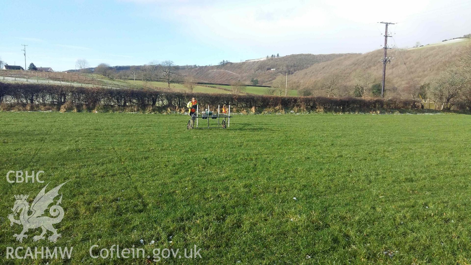 Photograph looking west showing SUMO geophysics survey in progress at west edge of field, taken by Sumo Survey on 25 January 2021. Part of Geophysical Survey of Pen y Wal, Dollwen Barrow, Goginan. Commissioned by the RCAHMW and produced by Sumo Survey, 2021.