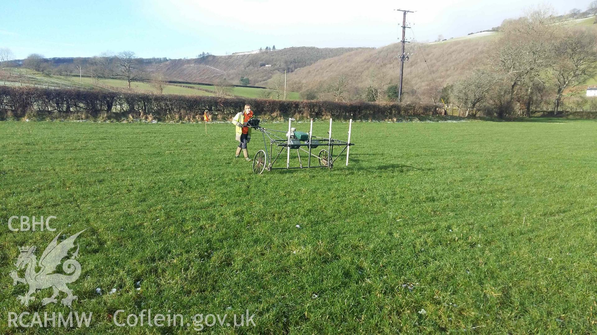 Photograph looking west showing SUMO geophysics survey in progress at west edge of field, taken by Sumo Survey on 25 January 2021. Part of Geophysical Survey of Pen y Wal, Dollwen Barrow, Goginan. Commissioned by the RCAHMW and produced by Sumo Survey, 2021.