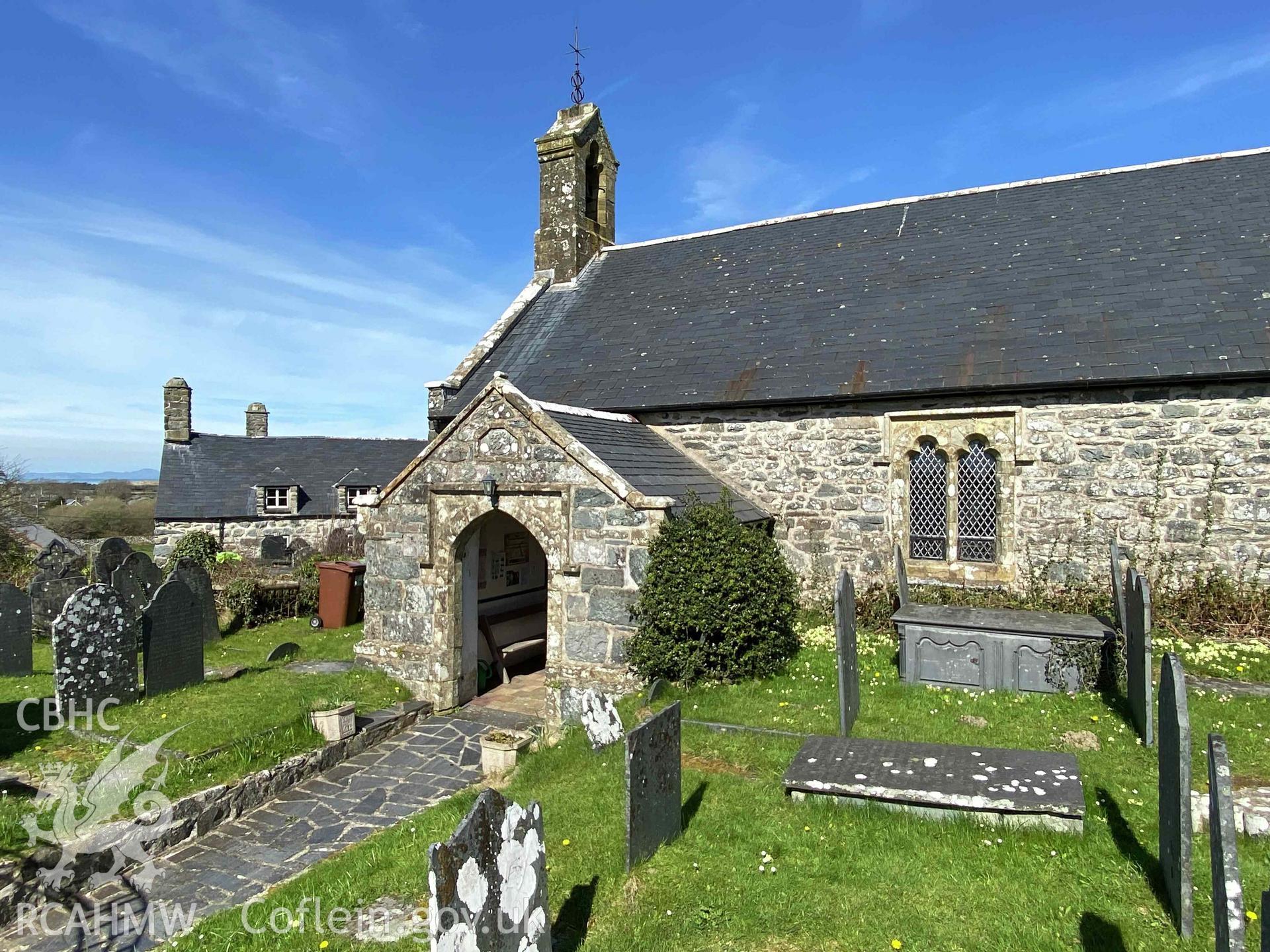 Digital photograph showing side elevation and porch of St Dwywe's Church, Llanddwywe-Is-y-Craig, produced by Paul Davis in 2023