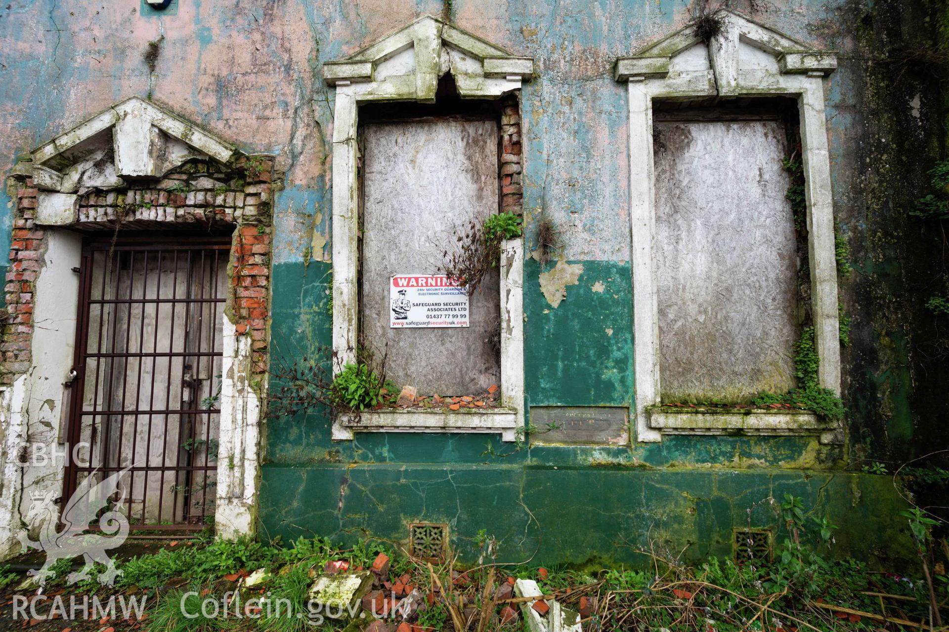 West front façade, north corner. Boarded windows and closed off doorway. Overgrown and derelict. Perrots Road Wesleyan Methodist Chapel, Haverfordwest. Part of a photographic survey conducted by Meilyr Powel on 20 February 2023.