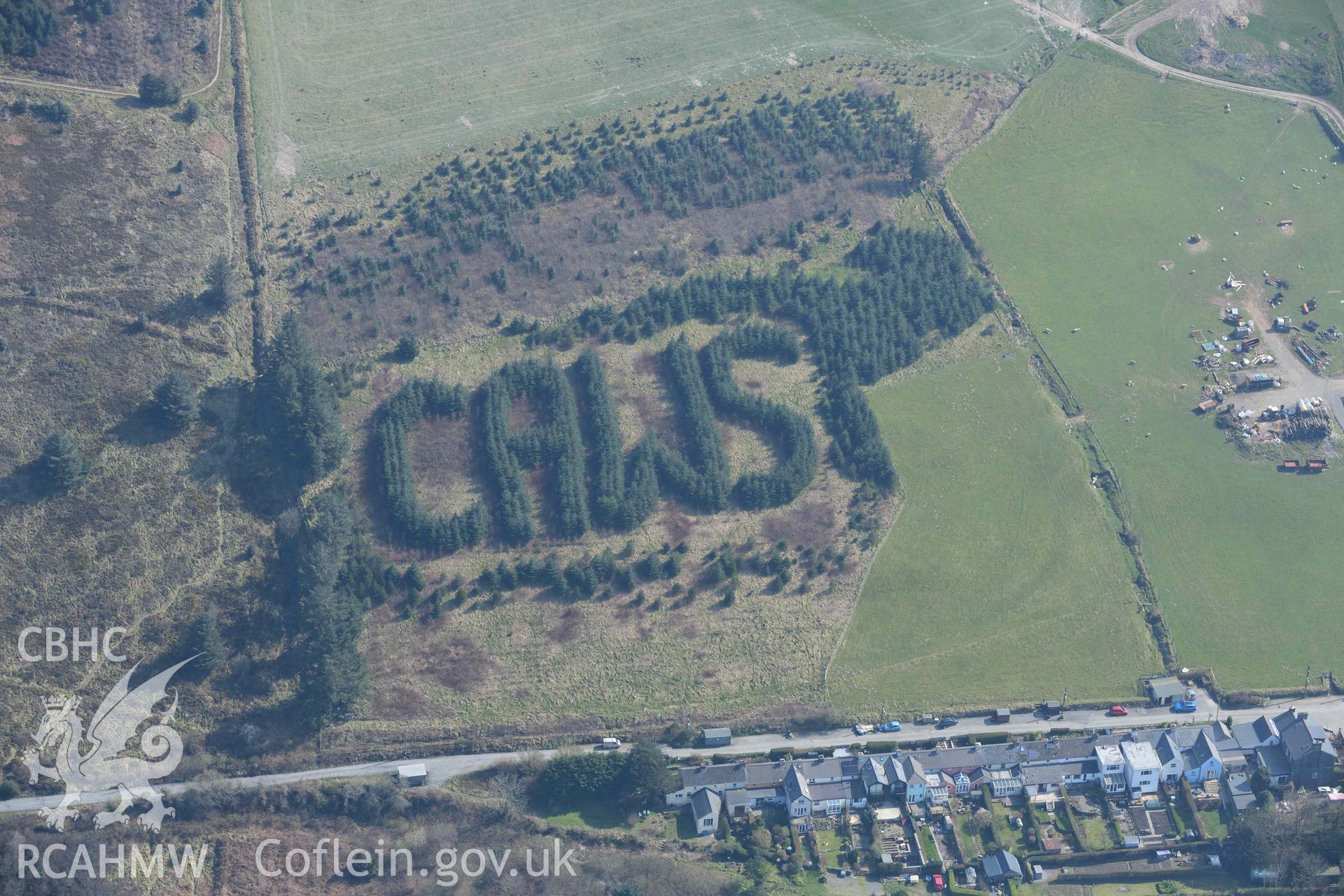 CAWS sign written with trees, Rosebush. Oblique aerial photographs taken during the Royal Commission’s programme of archaeological aerial reconnaissance by Toby Driver on 25 March 2022.