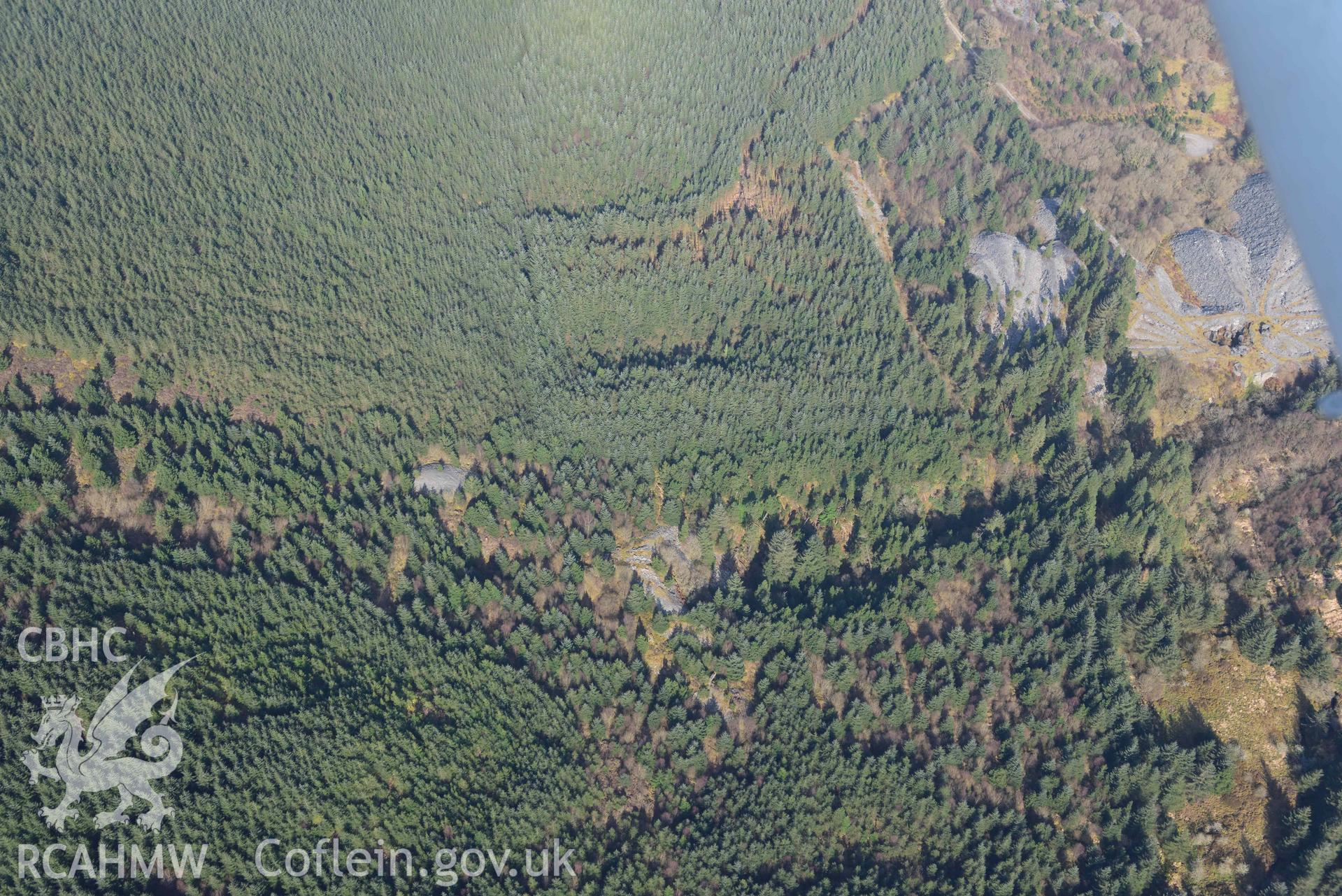 Bryneglwys Slate Quarry, forested tips. Oblique aerial photographs taken during the Royal Commission’s programme of archaeological aerial reconnaissance by Toby Driver on 25 March 2022.