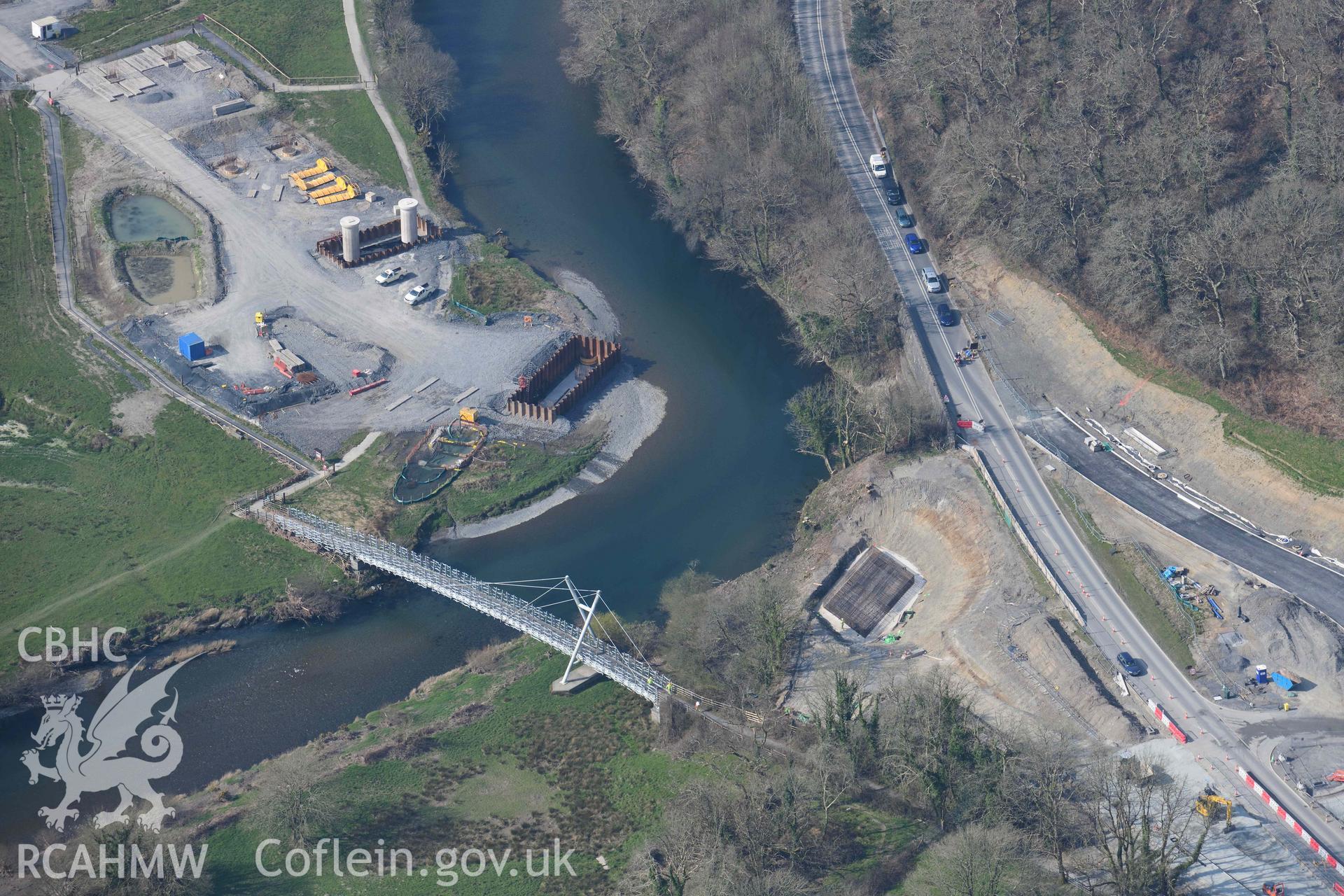 Millennium Bridge, Afon Ddyfi, with the new A487 road bridge under construction. Oblique aerial photograph taken during the Royal Commission’s programme of archaeological aerial reconnaissance by Toby Driver on 25 March 2022.