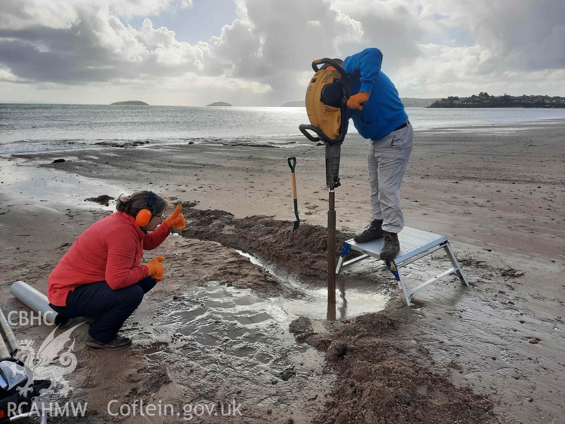 CHERISH sampling the peat. Part of a survey of the Submerged Forest, Peat Exposures and Footprints on The Warren Beach, Abersoch, conducted by Louise Barker on 21 October 2021. Produced with EU funds through the Ireland Wales Co-operation Programme 2014-2023. All material made freely available through the Open Government Licence.