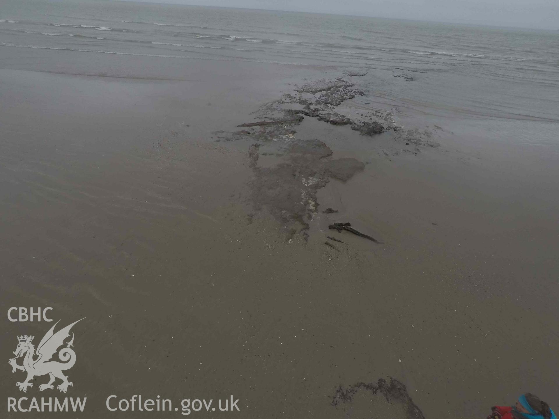 Peat exposure as recorded with pole camera.  View looking east. Part of survey of the Submerged Forest, Peat Exposures and Footprints on The Warren Beach, Abersoch, conducted by Toby Driver on 29 March 2021. Produced with EU funds through the Ireland Wales Co-operation Programme 2014-2023. All material made freely available through the Open Government Licence.