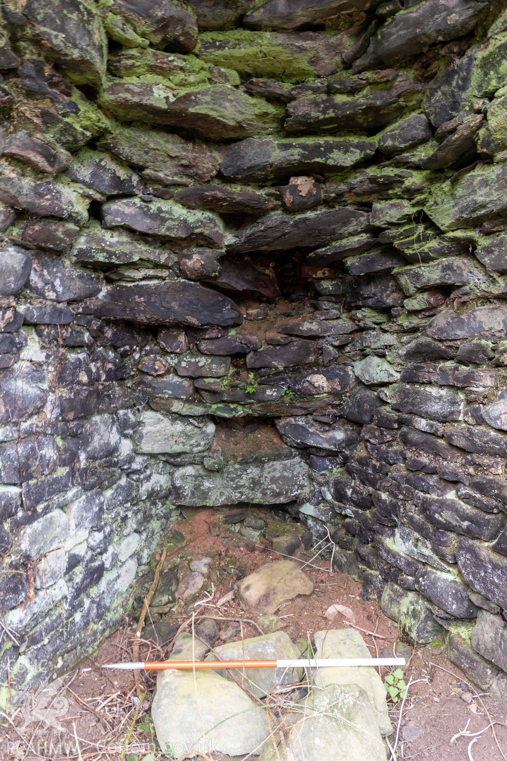 Kiln 2, draw-hole in kiln-eye, east elevation (with scale). Part of photographic survey of Aberstrincell lime kilns and coal yard, conducted by Louise Barker of the RCAHMW survey team on 21 March 2024.