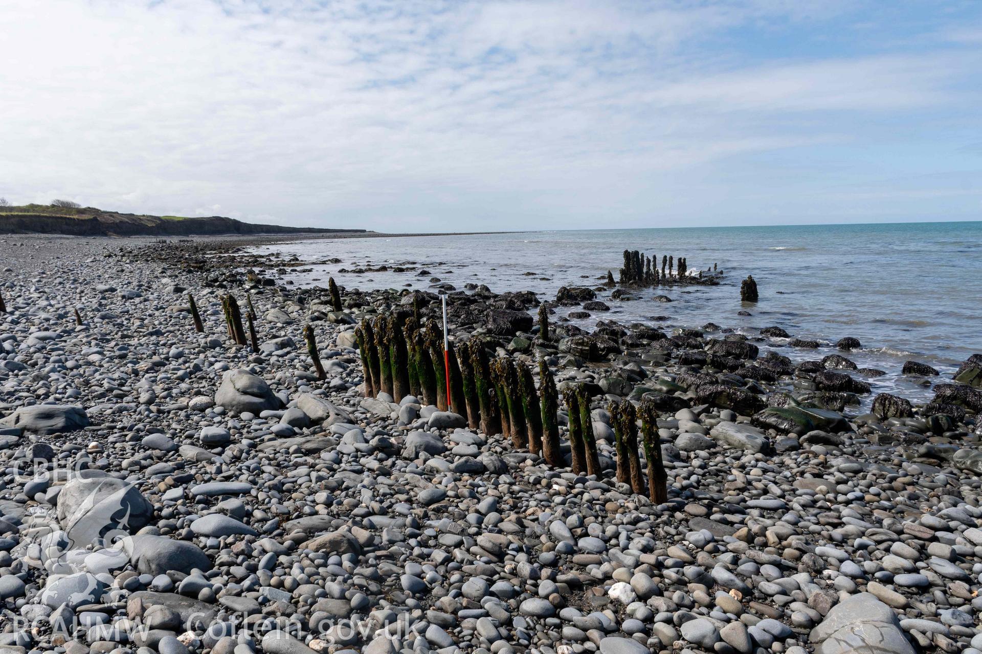 Groyne (SN5210768622) and Jetty (SN5214268626), Aberstrincell, looking northwest (with scale). Part of photographic survey of Aberstrincell lime kilns and coal yard, conducted by Louise Barker of the RCAHMW survey team on 21 March 2024.