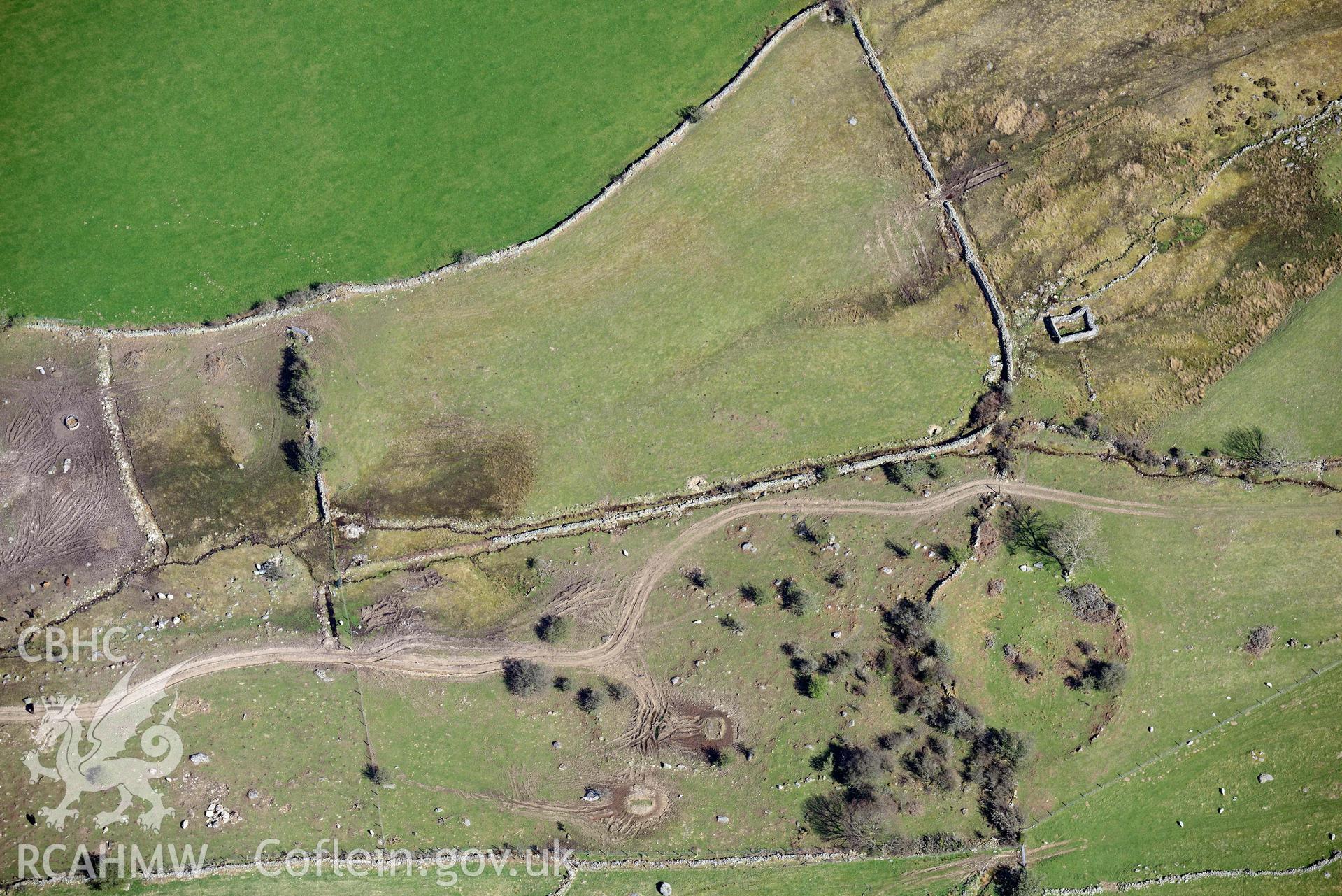 Llanllechid, enclosed hut group, with vehicle damage. Oblique aerial photograph taken during the Royal Commission’s programme of archaeological aerial reconnaissance by Toby Driver on 20 April 2018.