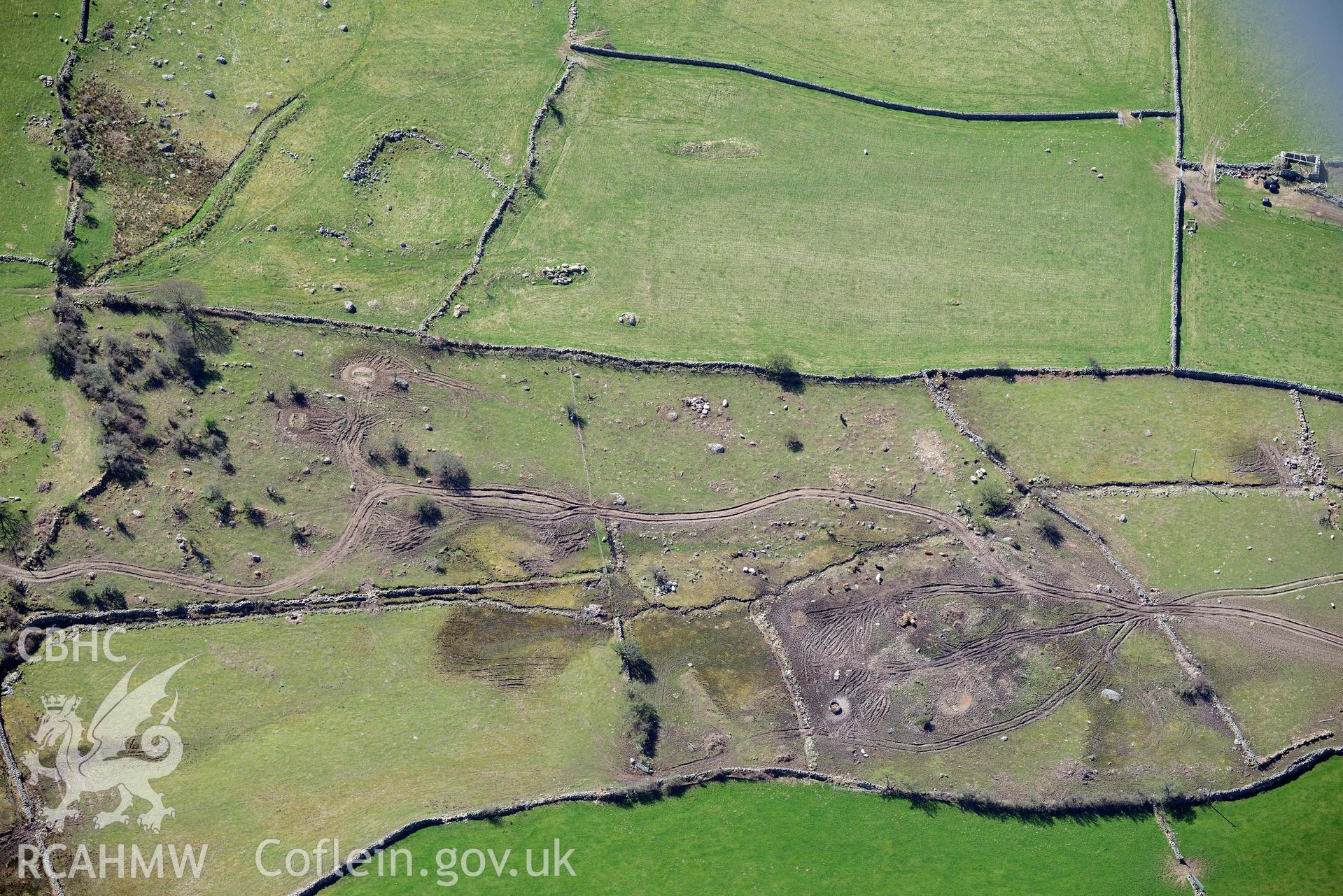 Llanllechid, enclosed hut group, with vehicle damage. Oblique aerial photograph taken during the Royal Commission’s programme of archaeological aerial reconnaissance by Toby Driver on 20 April 2018.