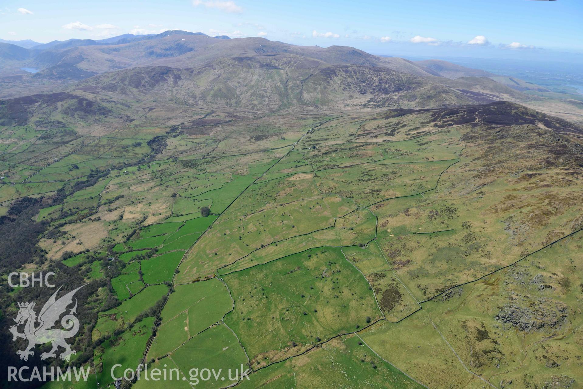 Field system near Maen y Bardd, panormaic landscape view from the east. Oblique aerial photograph taken during the Royal Commission’s programme of archaeological aerial reconnaissance by Toby Driver on 20 April 2018.