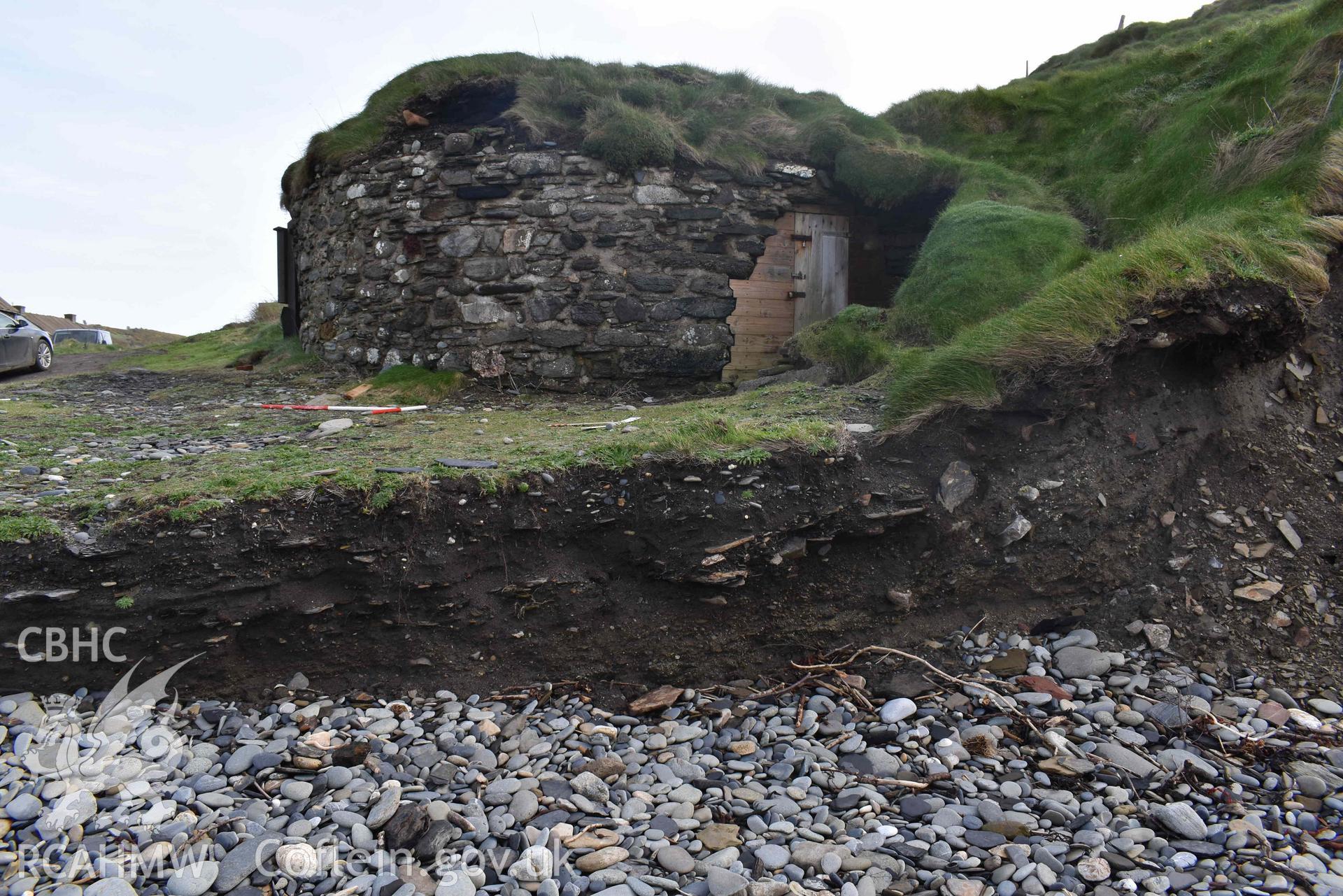 Abereiddy Lime Kiln 1 looking east from the top of the beach on 19/03/2024. The eroding face of the high water mark is in the foreground, scales are 1m. Produced by Julian Whitewright of the RCAHMW Survey Team.