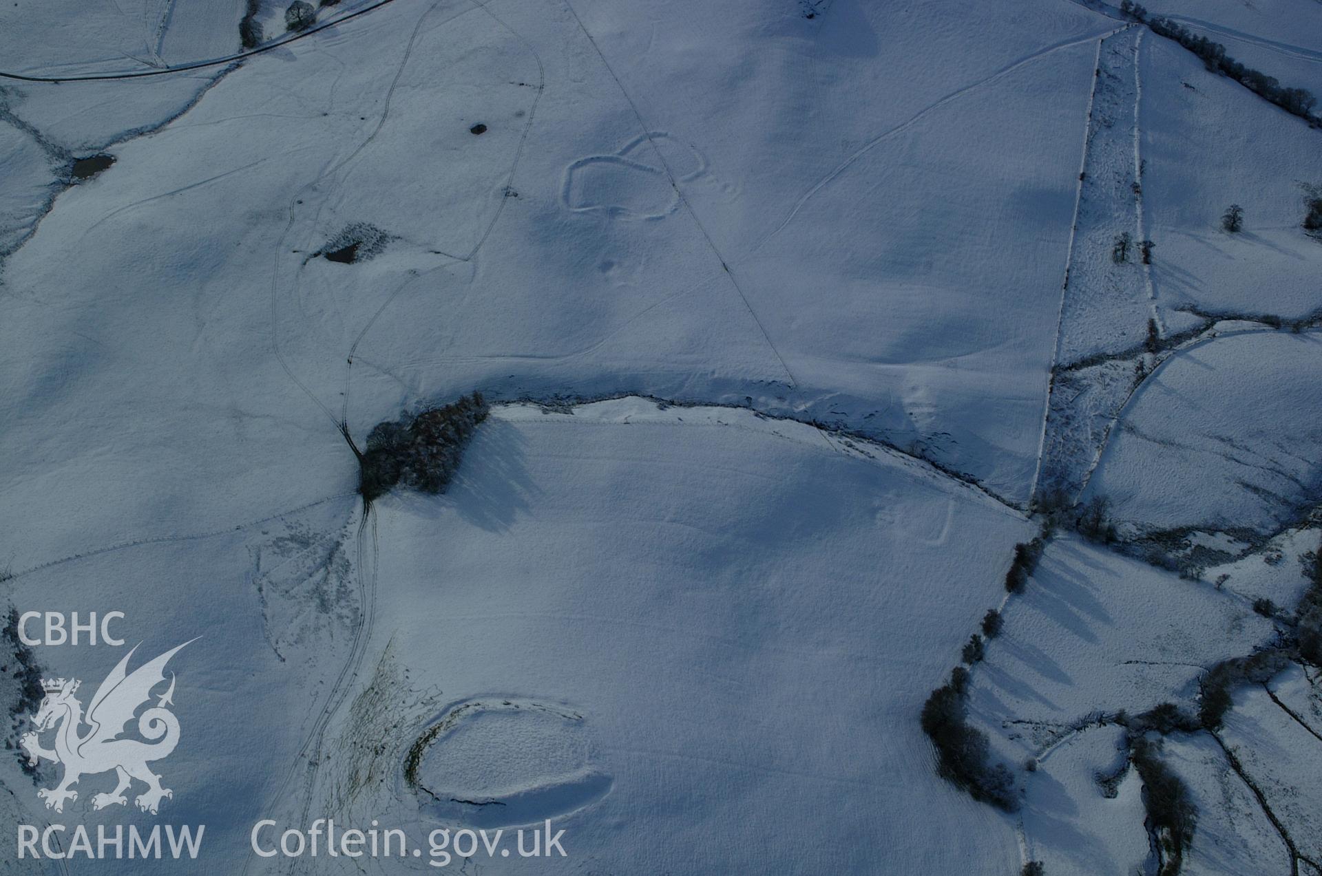 RCAHMW colour oblique aerial photograph of Castell Blaid Settlement from the north-east under snow. A smaller settlement is visible beyond. Taken on 19 November 2004 by Toby Driver