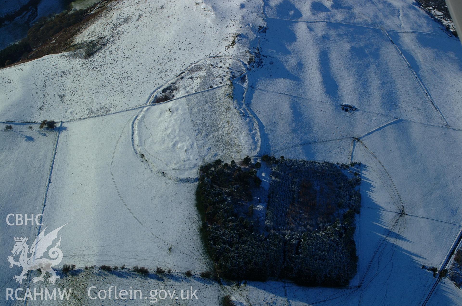 RCAHMW colour oblique aerial photograph of Cerrig Gwynion Defended Enclosure. A view from the east with the monument under snow. Taken on 19 November 2004 by Toby Driver