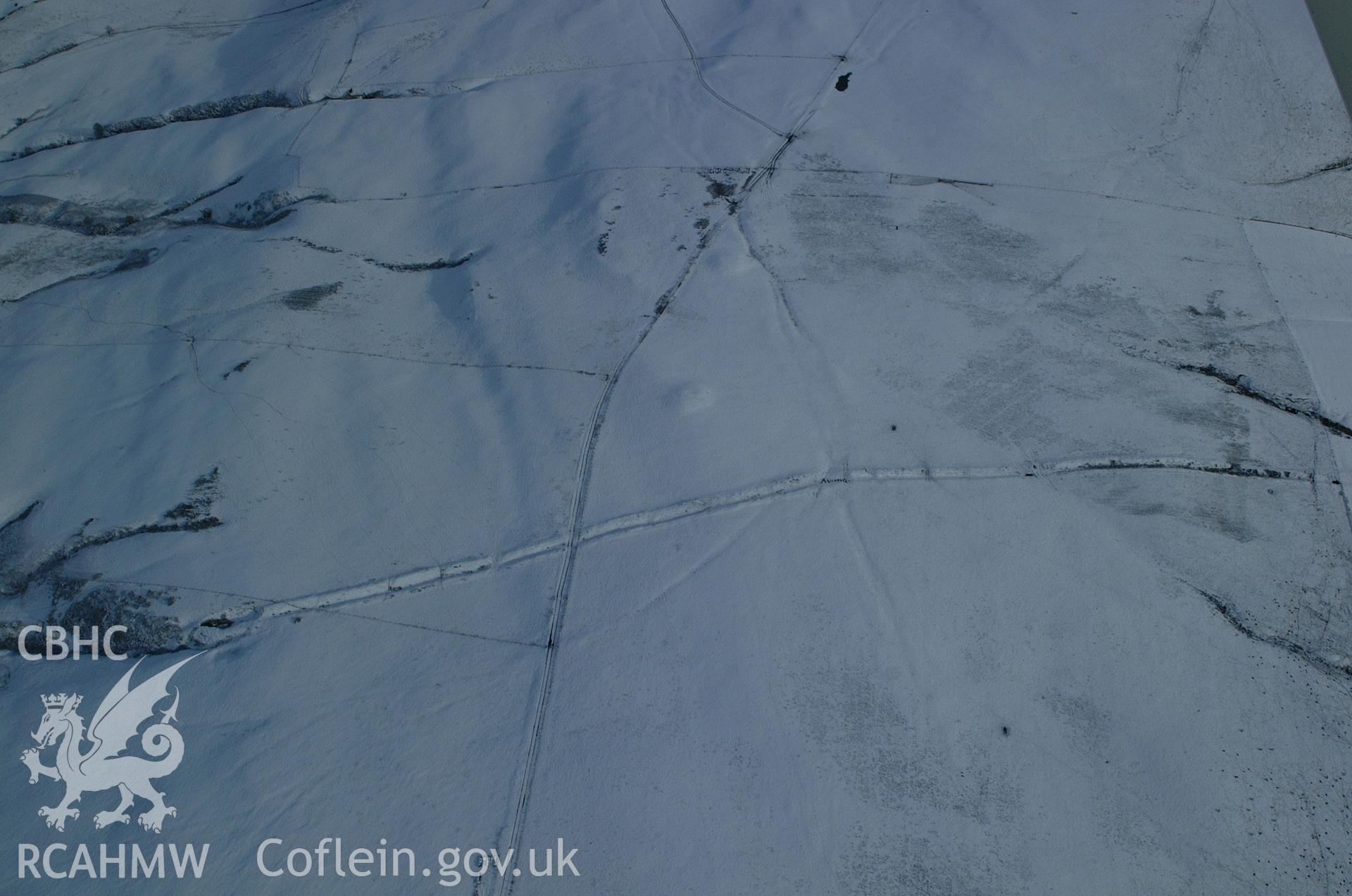 RCAHMW colour oblique aerial photograph of Two Tumps Dyke II and nearby barrows from the west under snow. Taken on 19 November 2004 by Toby Driver