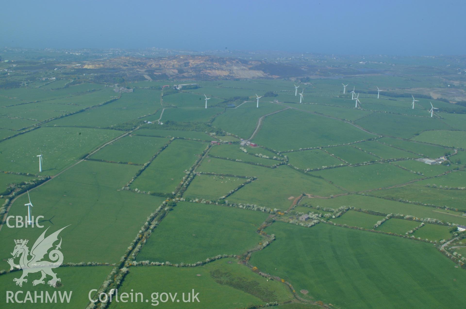 RCAHMW colour oblique aerial photograph of Trysglwn Wind Farm and Parys Mountain viewed from the south. Taken on 26 May 2004 by Toby Driver