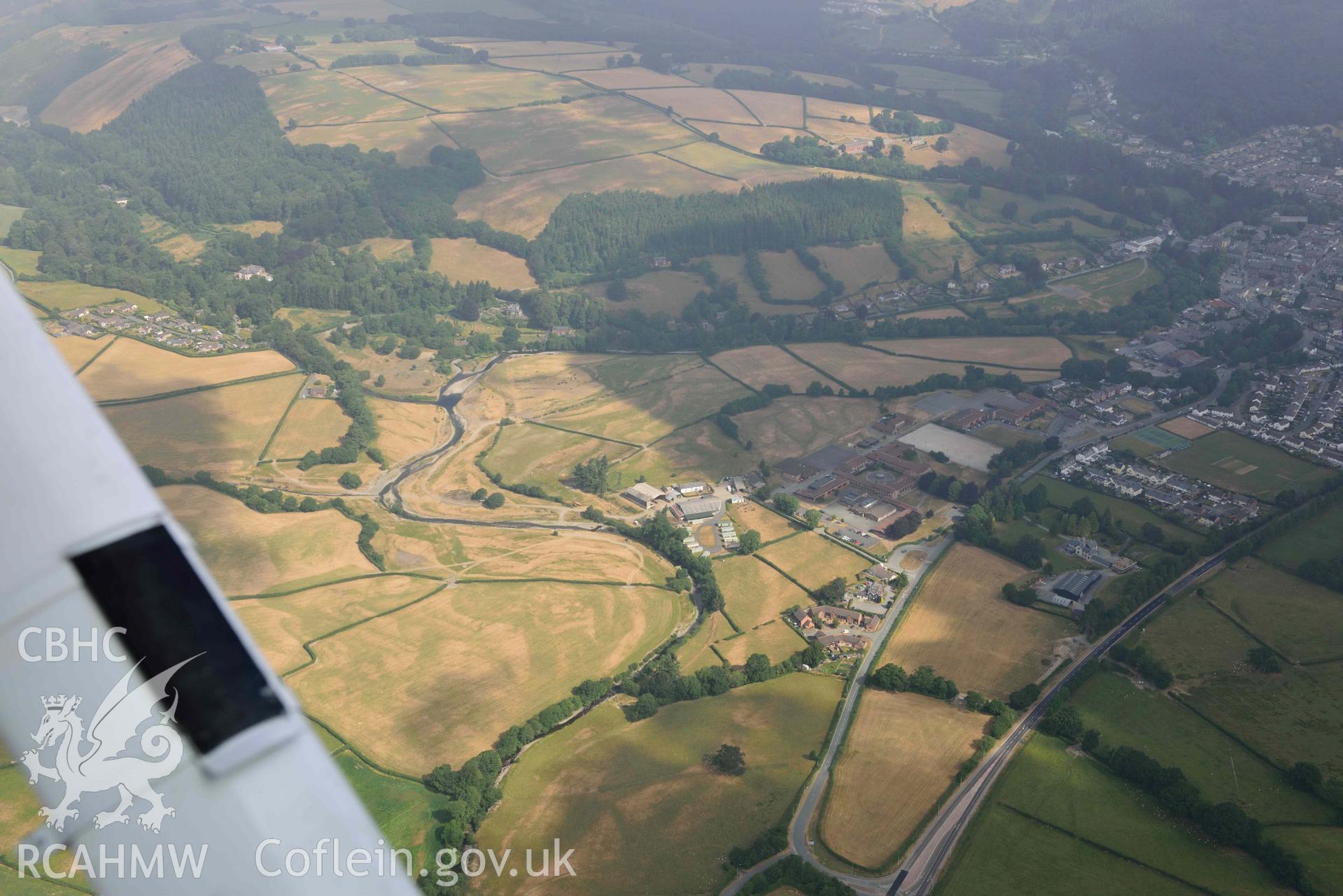 Llanidloes high school and town with parching. Oblique aerial photograph taken during the Royal Commission’s programme of archaeological aerial reconnaissance by Toby Driver on 10 July 2018.