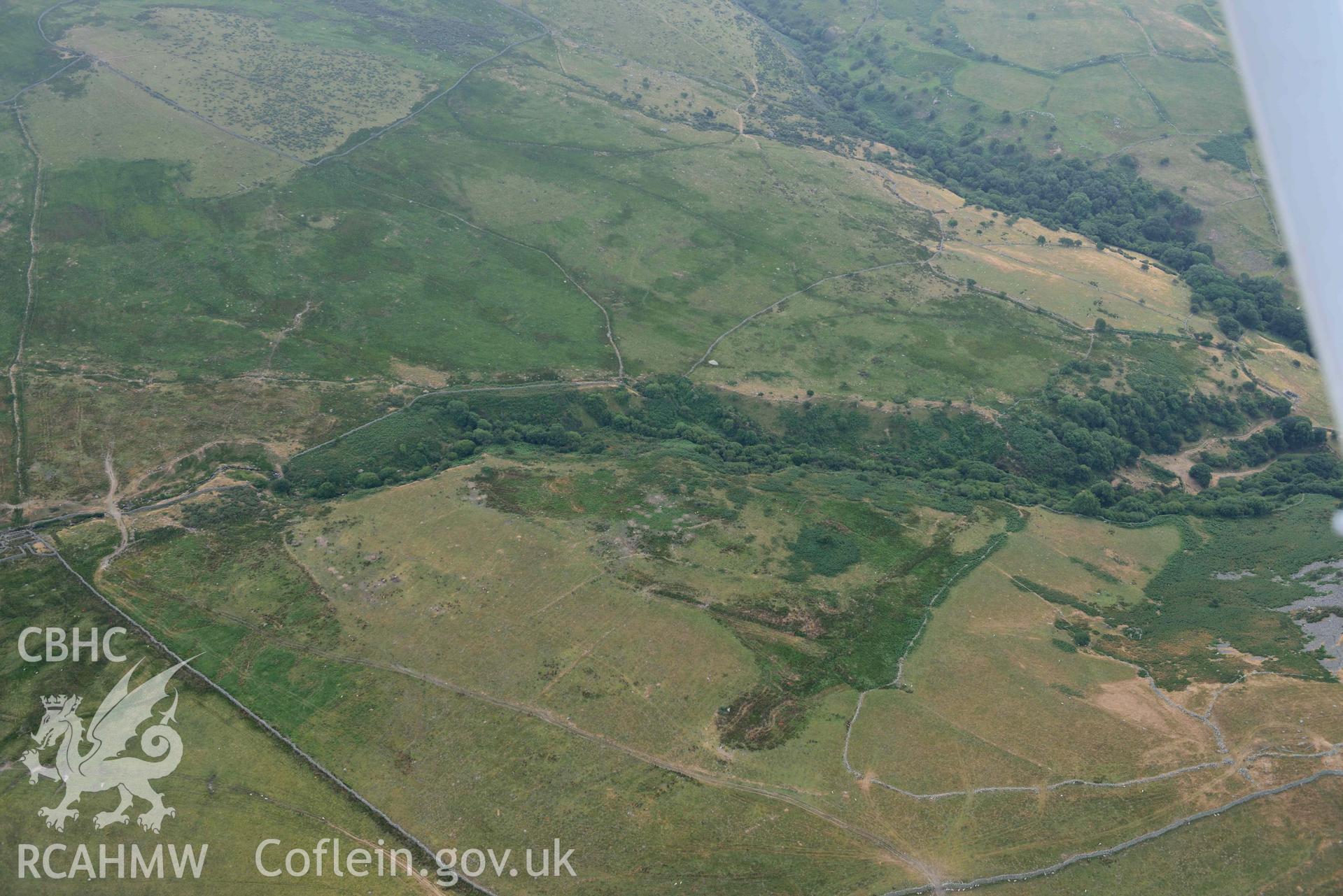 Dinas Llanfairfechan and hut circles near Dinas. Oblique aerial photograph taken during the Royal Commission’s programme of archaeological aerial reconnaissance by Toby Driver on 10 July 2018.