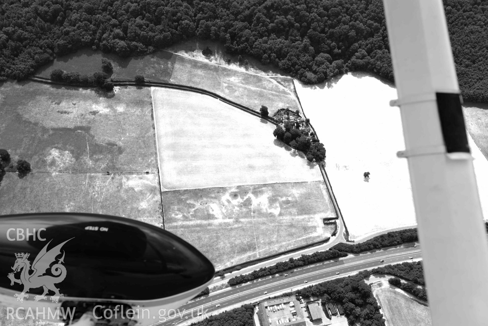 Madryn Roman Road. Oblique black and white aerial photograph taken during the Royal Commission’s programme of archaeological aerial reconnaissance by Toby Driver on 10 July 2018.