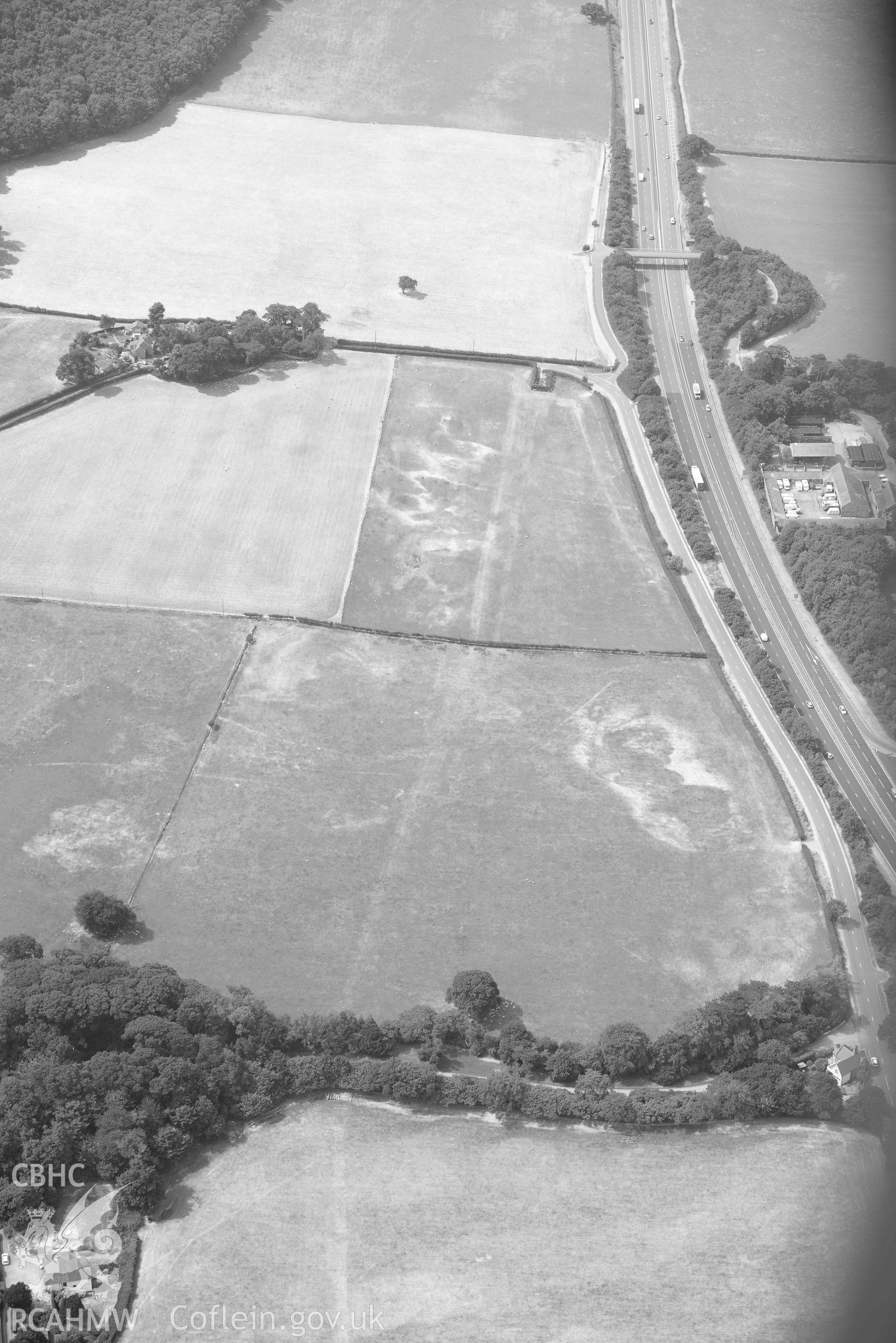 Madryn Roman Road. Oblique black and white aerial photograph taken during the Royal Commission’s programme of archaeological aerial reconnaissance by Toby Driver on 10 July 2018.