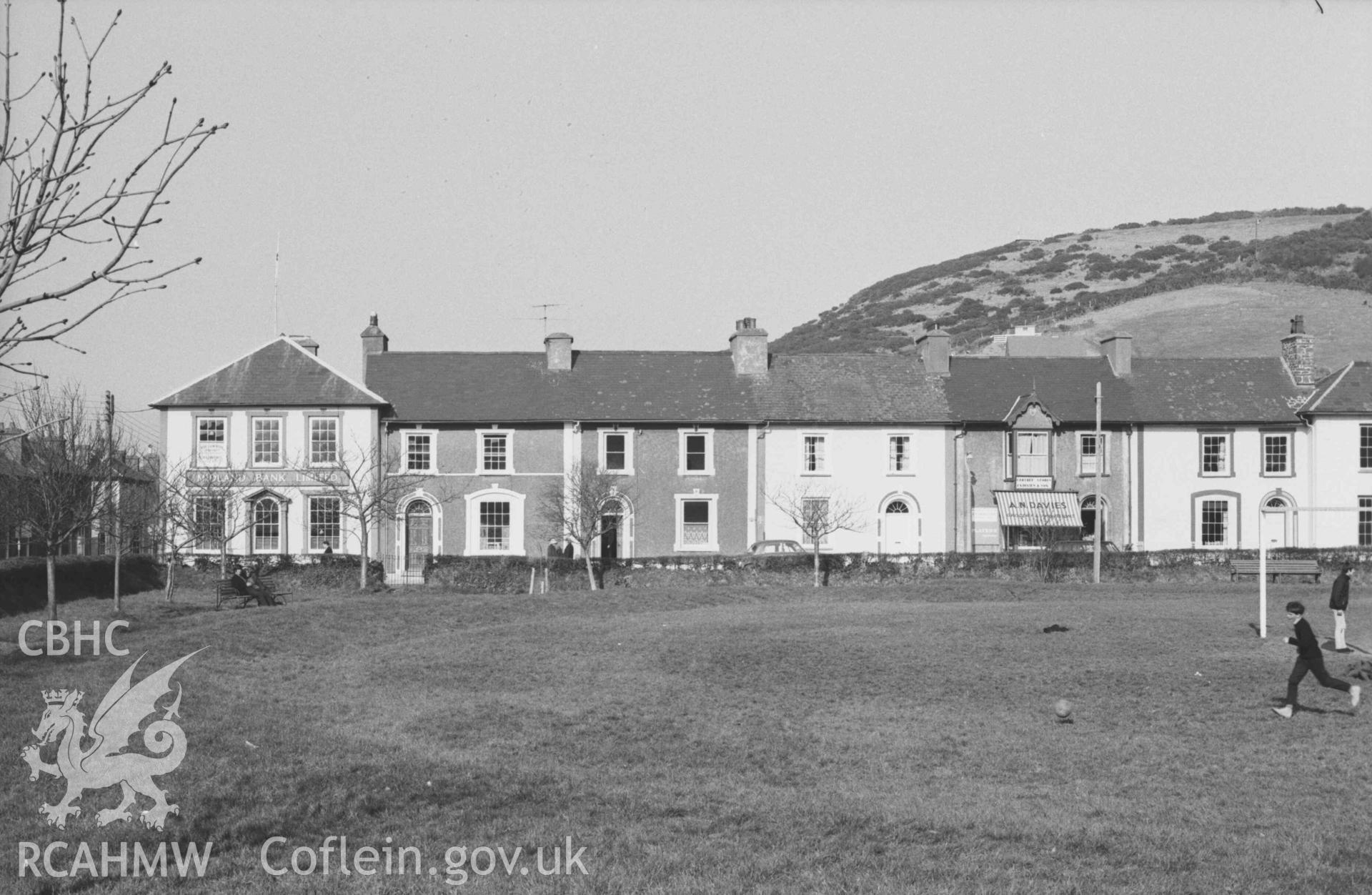 Digital copy of a black and white negative showing houses on the north east side of Alban Square, Aberaeron. Photographed by Arthur Chater on 3 April 1969. Looking north east from Grid Reference SN 4590 6287.