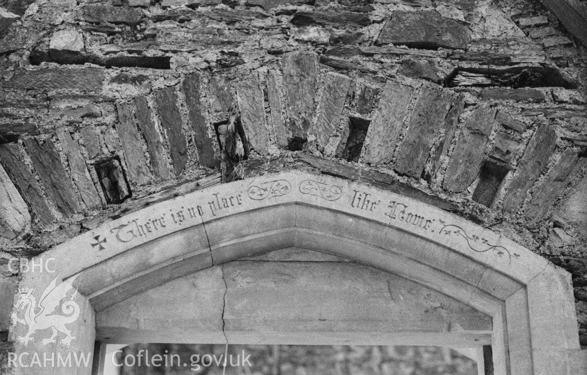 Digital copy of a black and white negative showing inscription 'There is no place like Home' carved and then painted, over a door or window inside the ruins of Bronwydd. Photographed by Arthur Chater on 5 April 1969. Grid Reference SN 3532 4322.