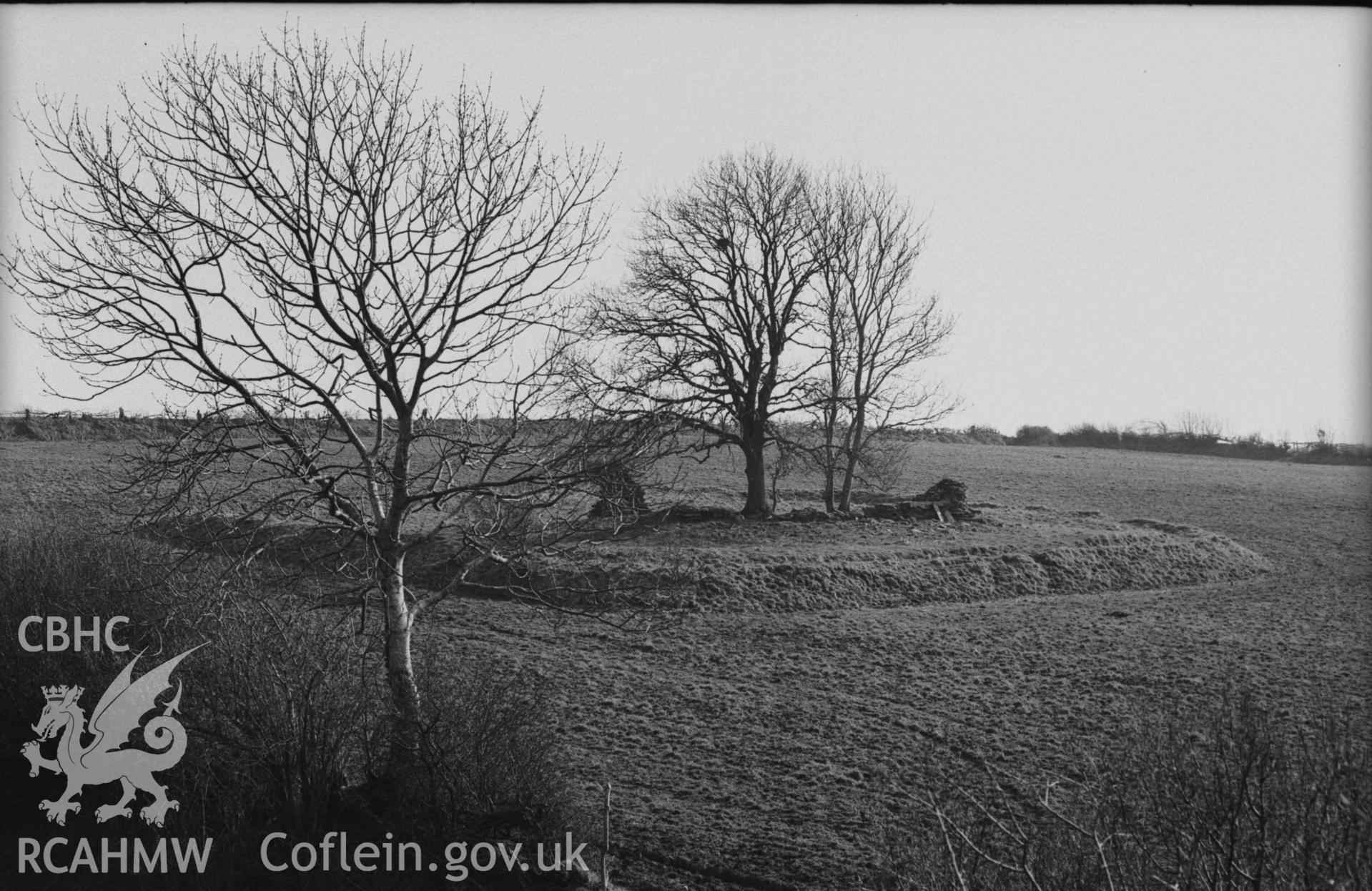 Digital copy of a black and white negative showing Llanfairtrefhelygen church ruins from the top of the Norman motte. Photographed by Arthur Chater on 5 April 1969. Looking south west from Grid Reference SN 3440 4422.