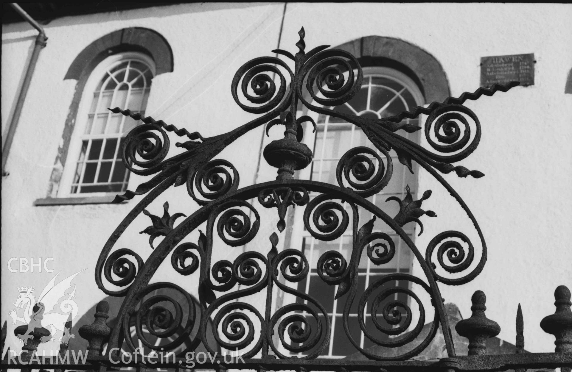 Digital copy of a black and white negative showing tomb of the Rev. Benjamin Evans with wrought ironwork in front of Capel Hawen. Photographed by Arthur Chater on 5 April 1969. Grid Reference SN 3464 4680.