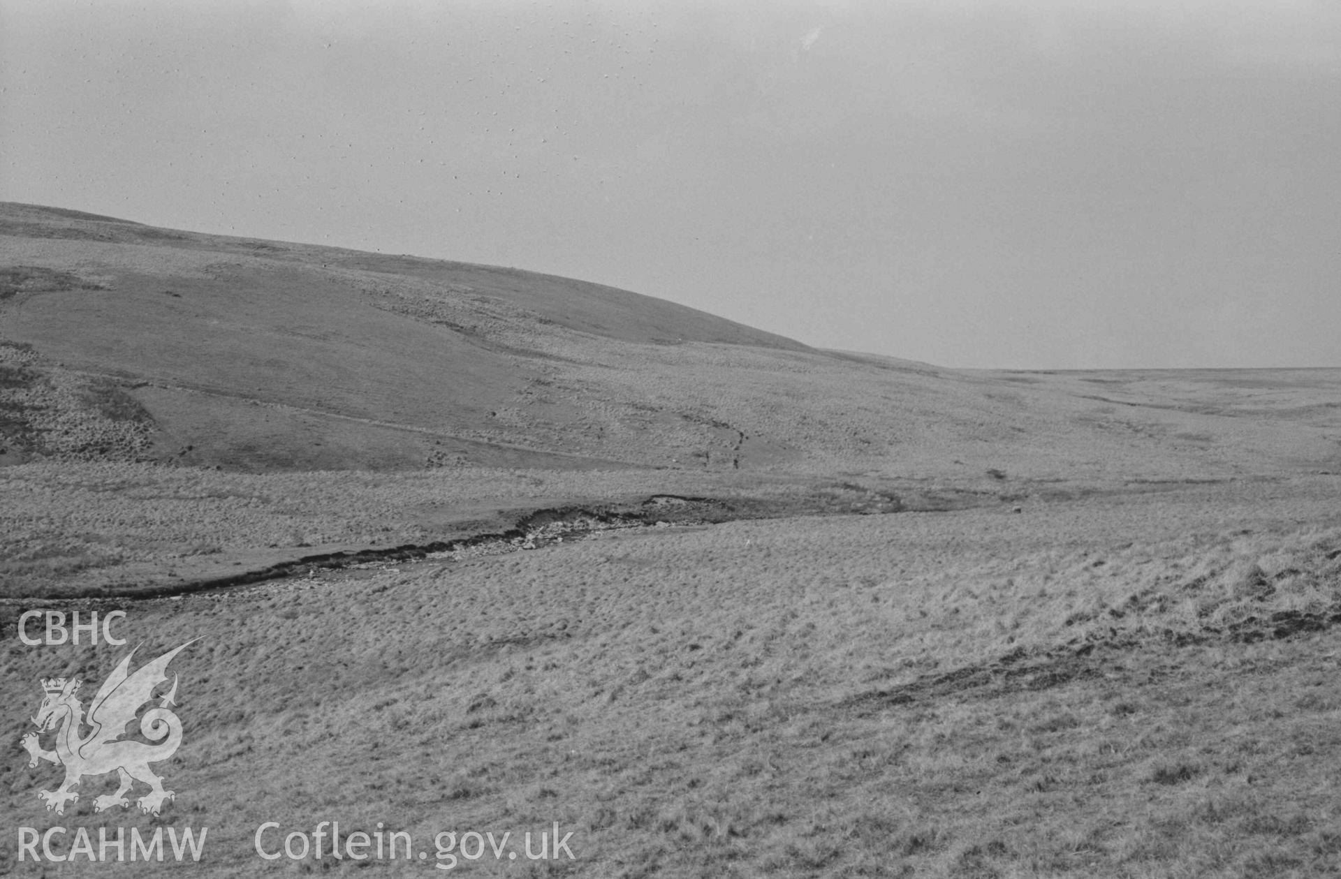 Digital copy of a black and white negative showing view across the Afon Claerwen to Esgair Hengae, showing old road sloping down from left to right, ruins of Hengae (just right of centre) and Rhyd Hengae (extreme right). Panoramic view, photo 3 of 3. Photographed by Arthur Chater on 8 April 1969. Grid Reference SN 8220 6780.