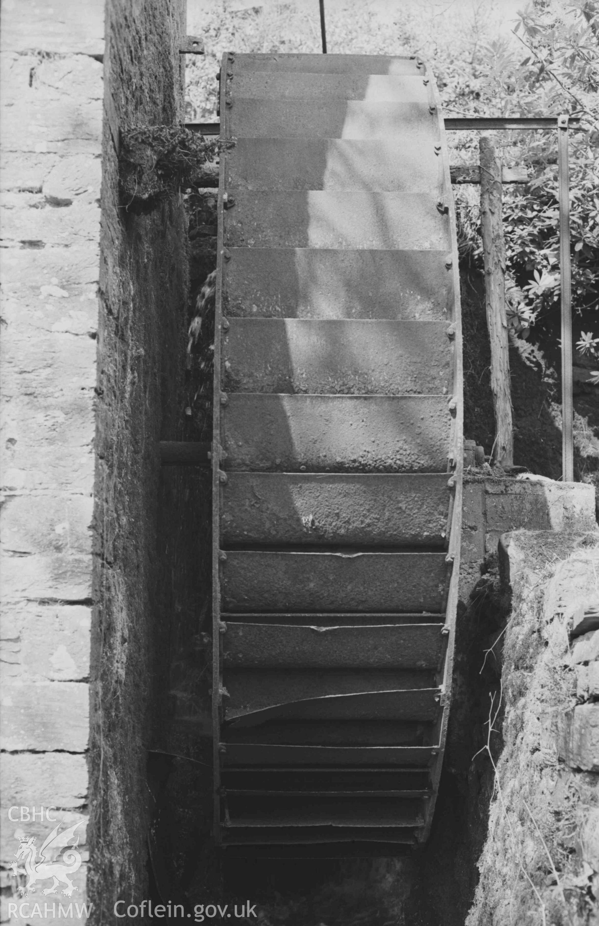 Digital copy of a black and white negative showing iron overshot waterwheel at Felin-Wnda mill. Photographed by Arthur Chater on 7 April 1969. Looking north west from Grid Reference SN 3235 4692.