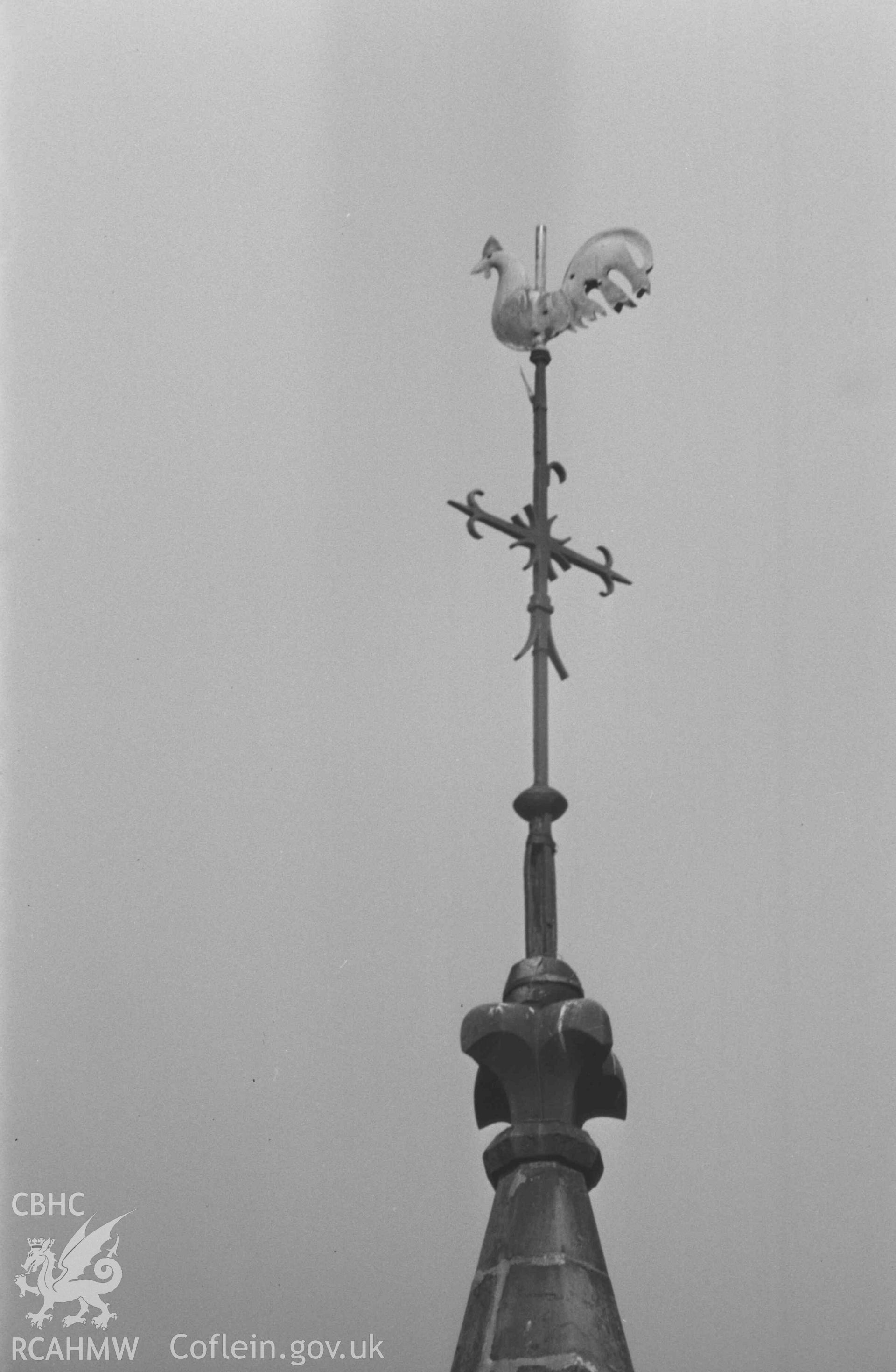 Digital copy of a black and white negative showing weathercock on the west turret of All Saints' Churchyard, Llangorwen. Photographed by Arthur Chater on 12 April 1969. Looking north west from Grid Reference SN 6035 8380.