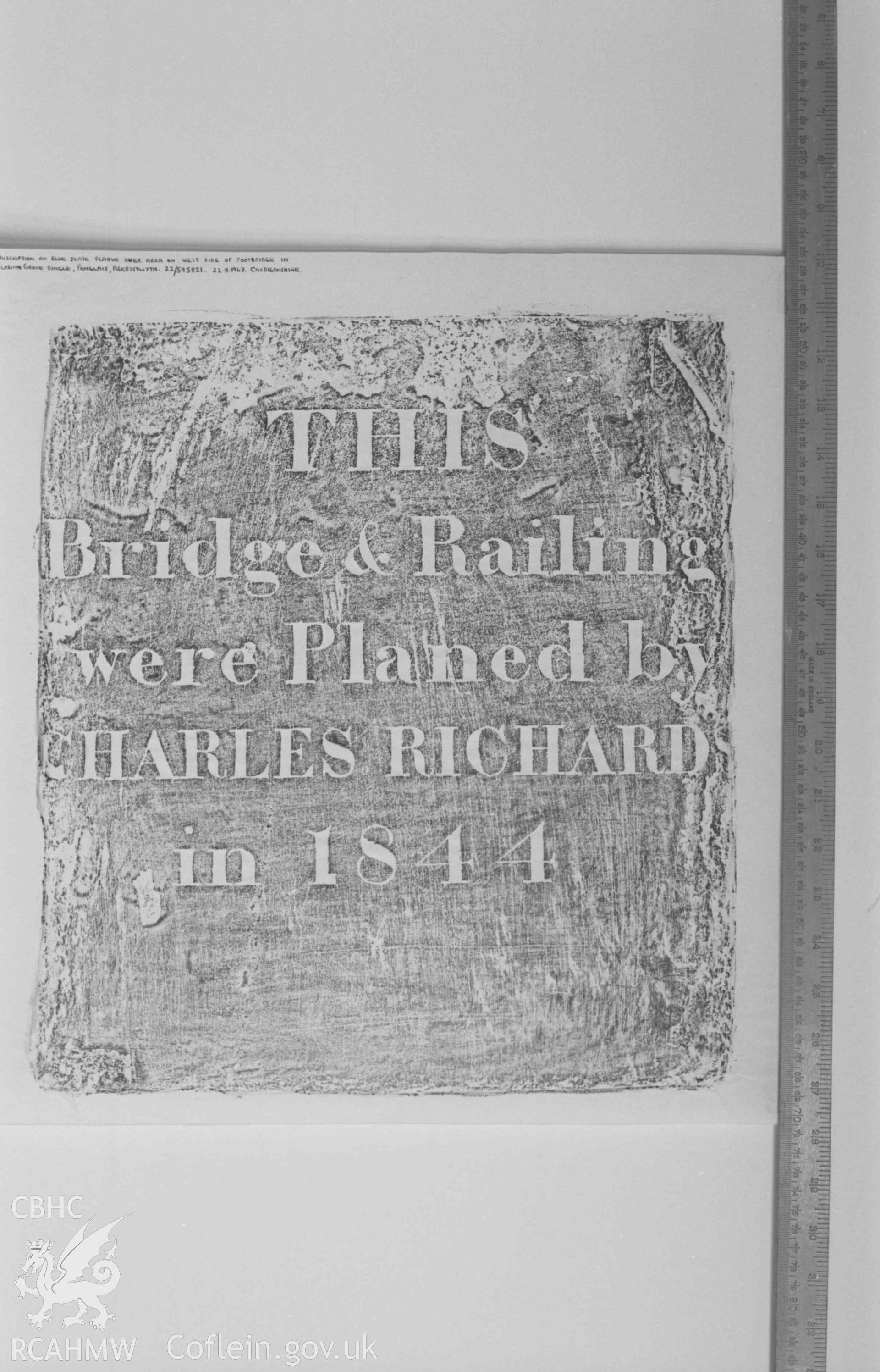 Digital copy of a black and white negative showing rubbing of plaque on arch on the west side of the footbridge in Elysian Grove Dingle, Penglais. Produced by Arthur Chater on 26 August 1969.