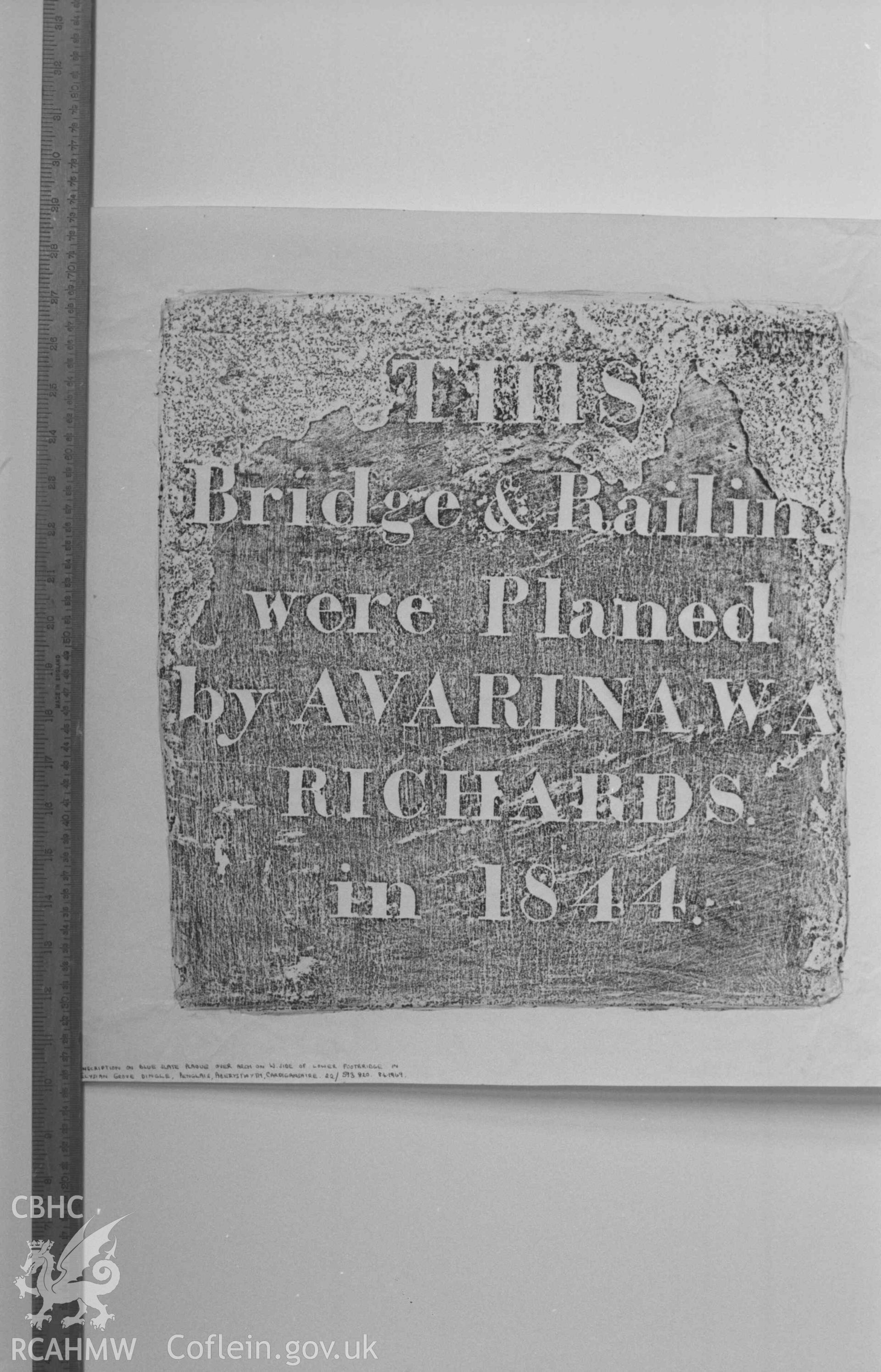 Digital copy of a black and white negative showing rubbing of plaque on arch on the west side of the footbridge in Elysian Grove Dingle, Penglais. Produced by Arthur Chater on 26 August 1969.
