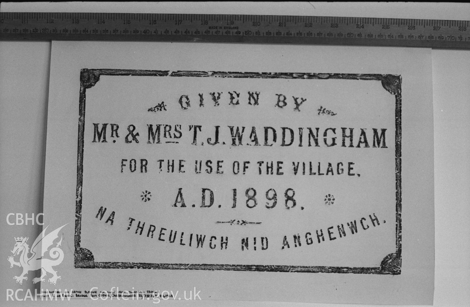 Digital copy of a black and white negative showing rubbing plaque on cast iron drinking trough just east of Devil's Bridge Post Office. Produced by Arthur Chater on 26 August 1969.