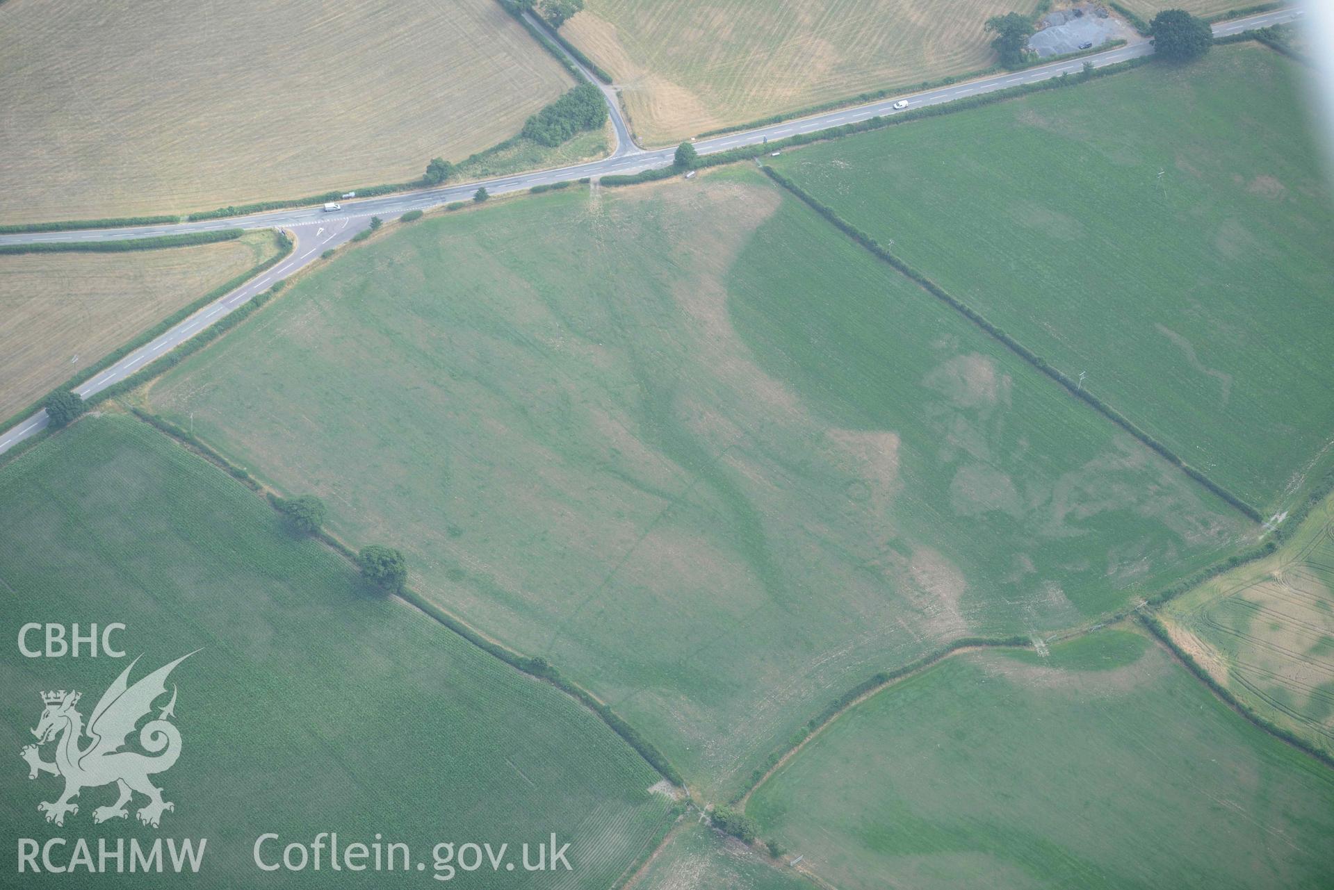 Maes Mochnant mound and cropmarks. Oblique aerial photograph taken during the Royal Commission’s programme of archaeological aerial reconnaissance by Toby Driver on 10 July 2018.