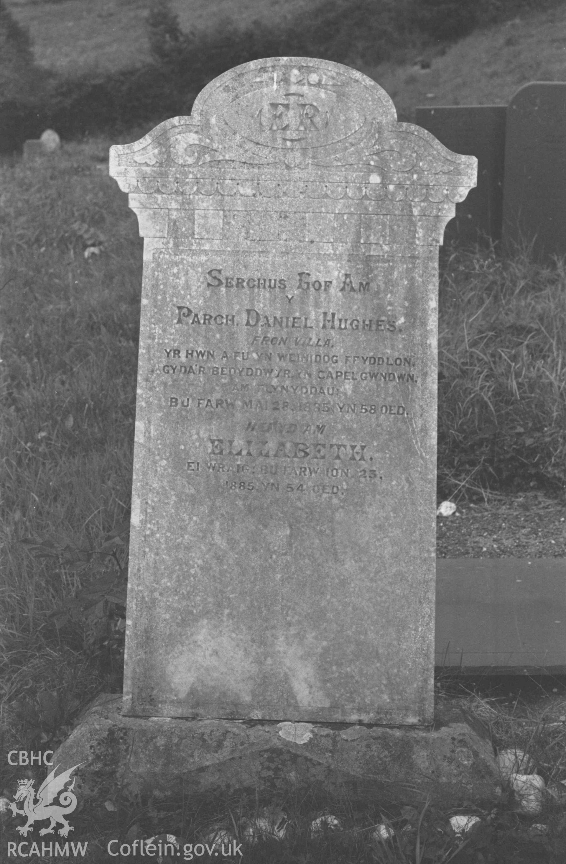 Digital copy of a black and white negative showing tombstone of Daniel Hughes (minister of Capel Gwndwn) at Capel Llwyndafydd graveyard. Photographed by Arthur Chater on 28 August 1969, looking north west from Grid Reference SN 3703 5558.