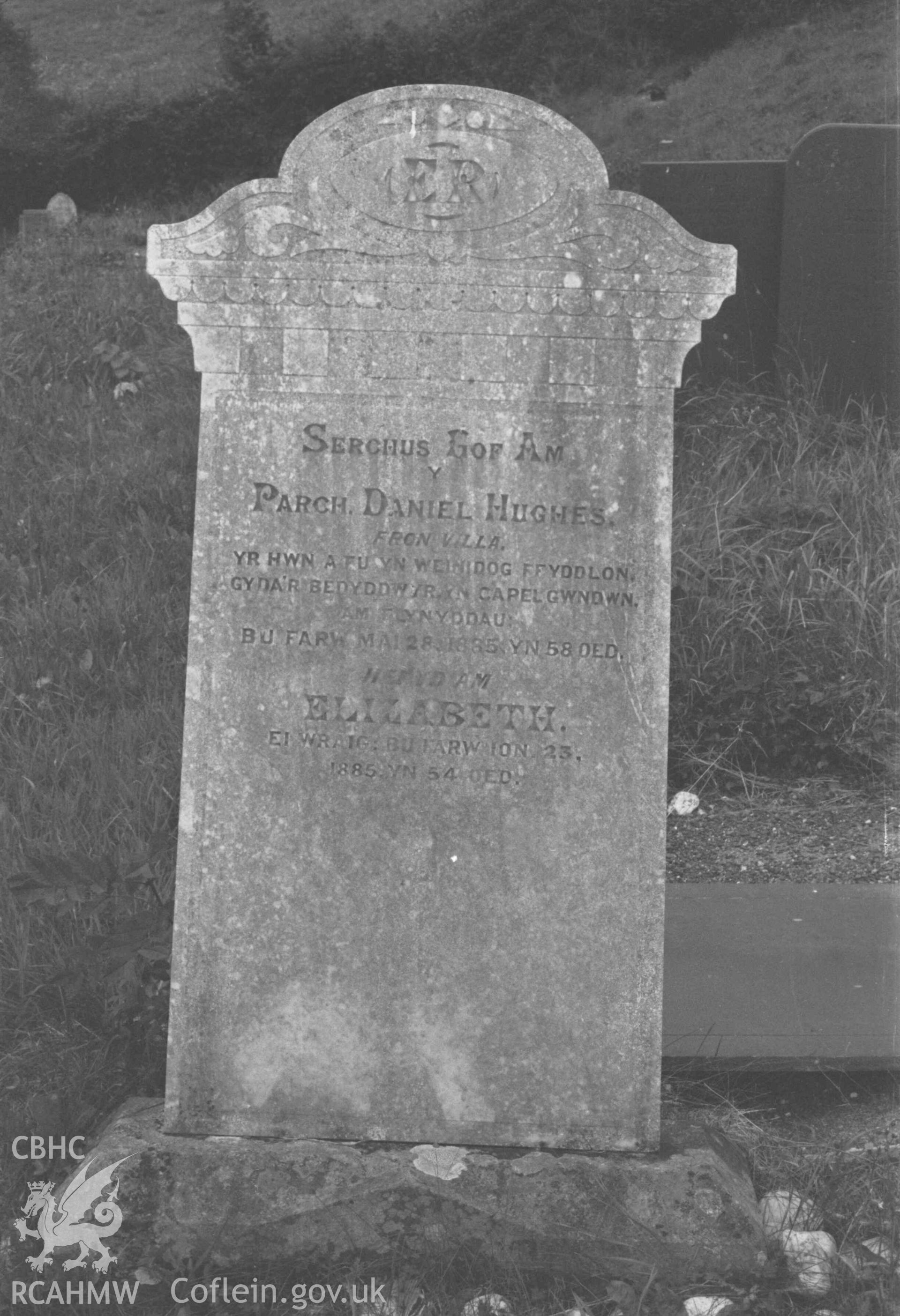 Digital copy of a black and white negative showing tombstone of Daniel Hughes (minister of Capel Gwndwn) at Capel Llwyndafydd graveyard. Photographed by Arthur Chater on 28 August 1969, looking north west from Grid Reference SN 3703 5558.