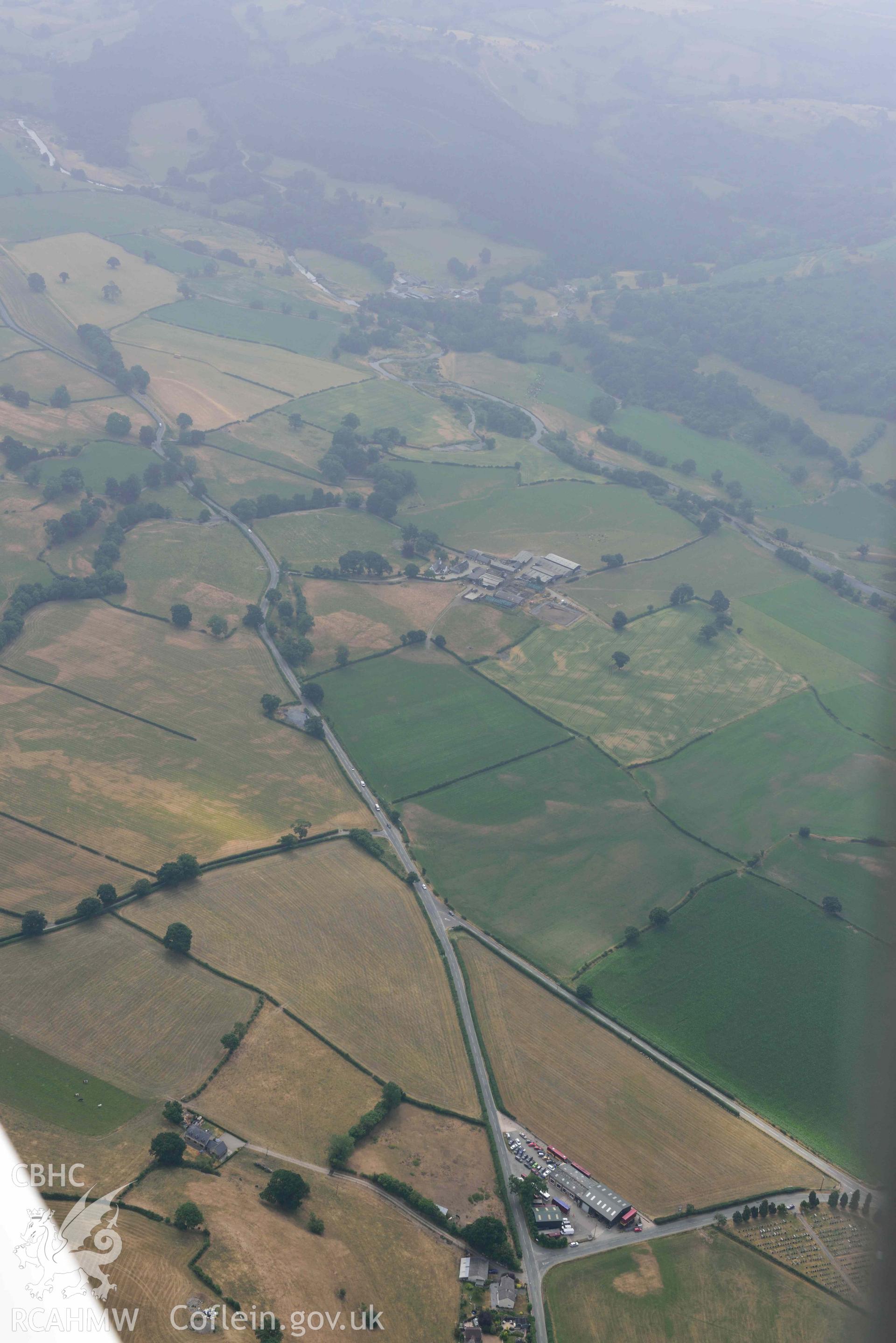 Maes Mochnant mound and cropmarks. Oblique aerial photograph taken during the Royal Commission’s programme of archaeological aerial reconnaissance by Toby Driver on 10 July 2018.