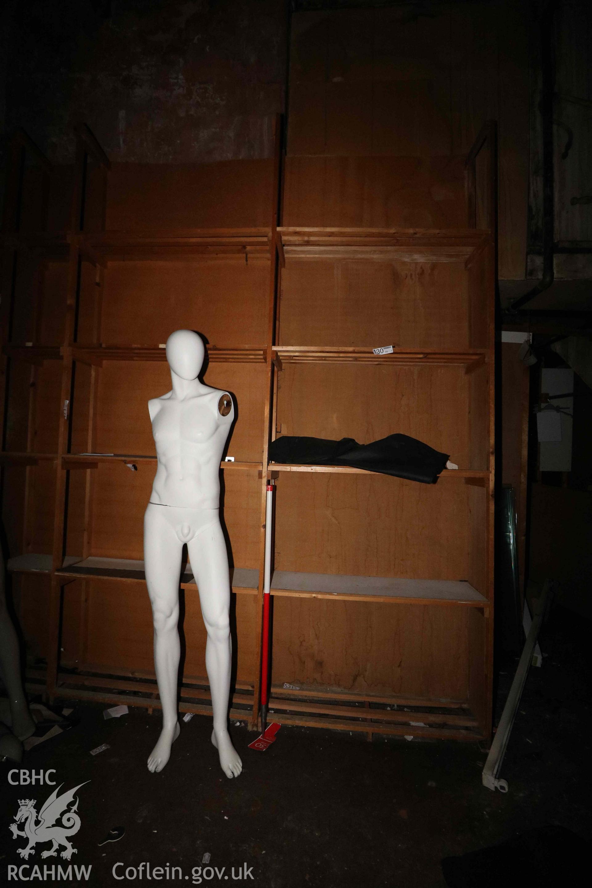 Photograph showing ground floor storeroom - male mannequin, from a Level 4 Historic Building Record of the former Howells Department Store, Cardiff. Conducted as a part of listed building consent by Purcell Architecture in 2024.