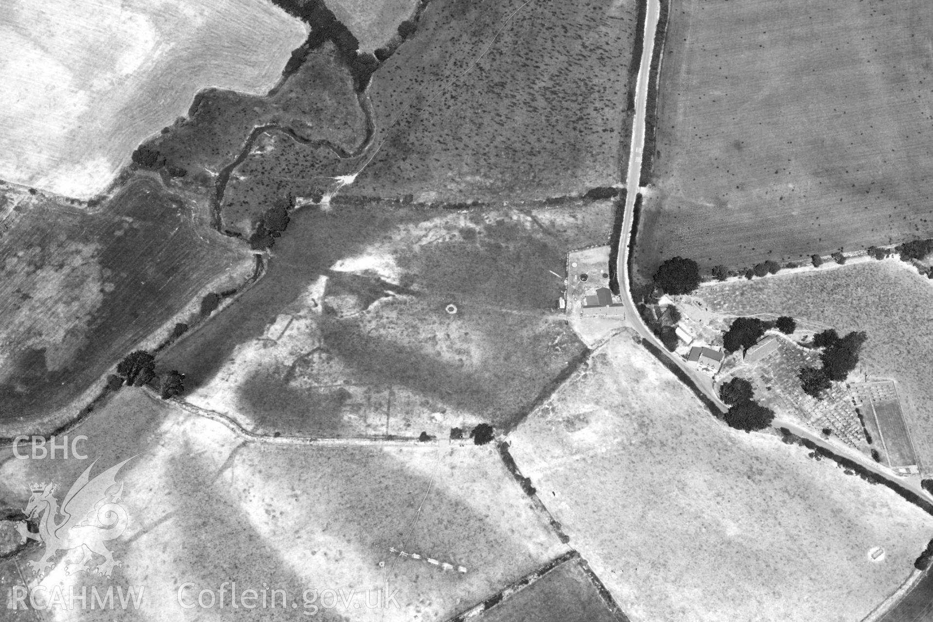 St Gwynnins Church and Tyn Llan square enclosure. Oblique black and white aerial photograph taken during the Royal Commission’s programme of archaeological aerial reconnaissance by Toby Driver on 10 July 2018.