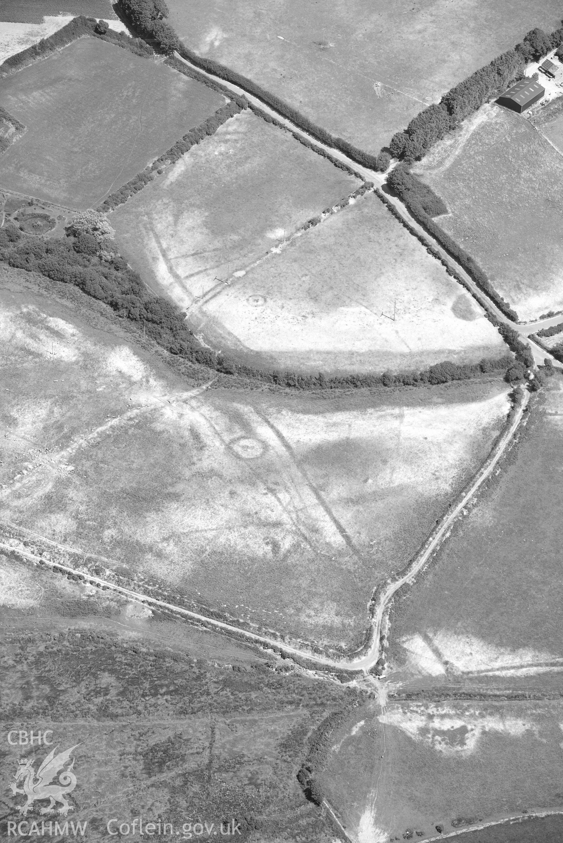 Detailed view of cropmark complex at Llawr-Dref, Llangian. Oblique black and white aerial photograph taken during the Royal Commission’s programme of archaeological aerial reconnaissance by Toby Driver on 10 July 2018.