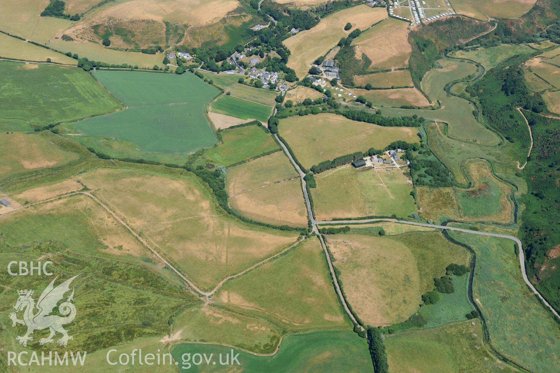 Landscape around cropmark complex at Llawr-Dref and Llangian village. Oblique aerial photograph taken during the Royal Commission’s programme of archaeological aerial reconnaissance by Toby Driver on 10 July 2018.