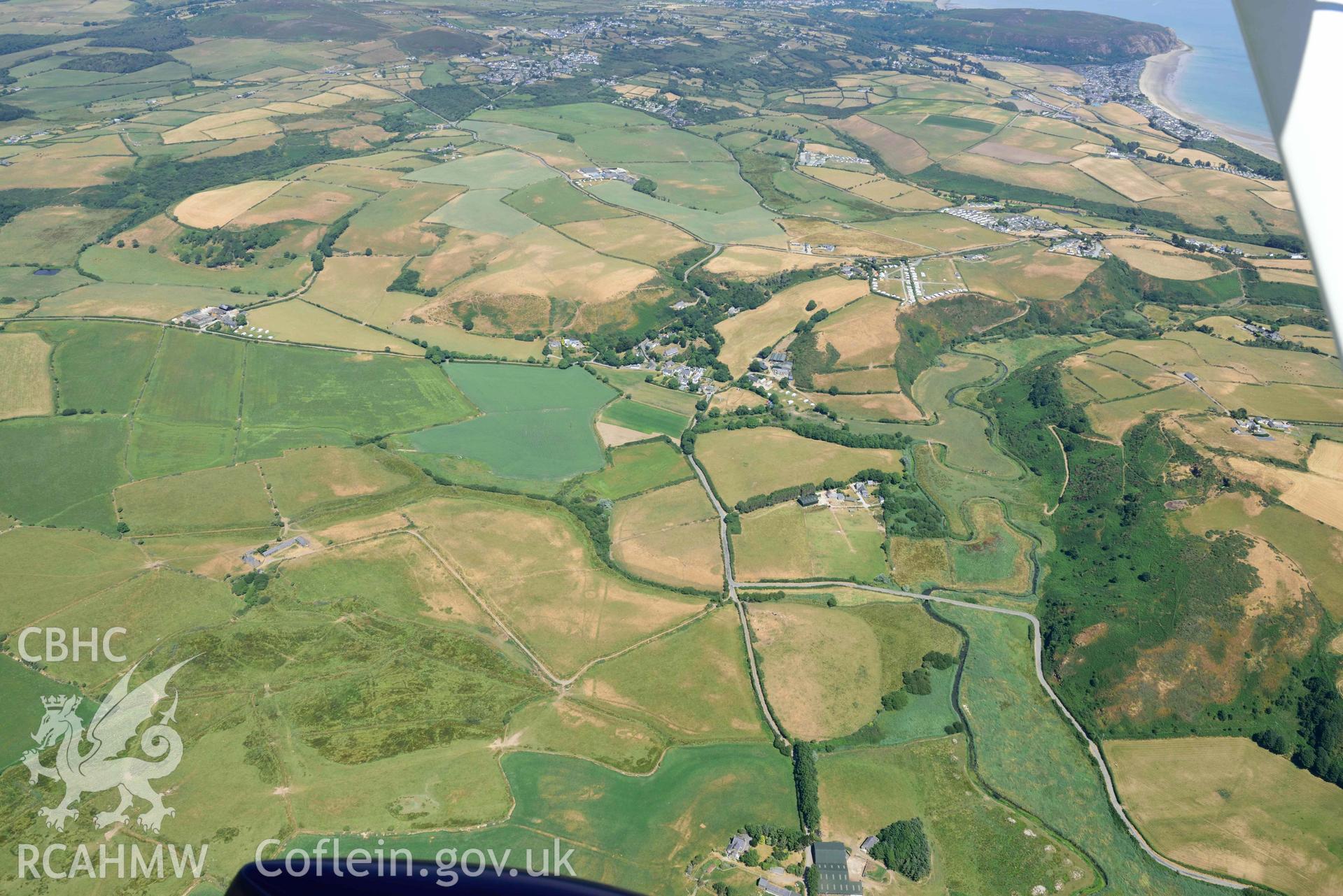 Landscape around cropmark complex at Llawr-Dref and Llangian village. Oblique aerial photograph taken during the Royal Commission’s programme of archaeological aerial reconnaissance by Toby Driver on 10 July 2018.