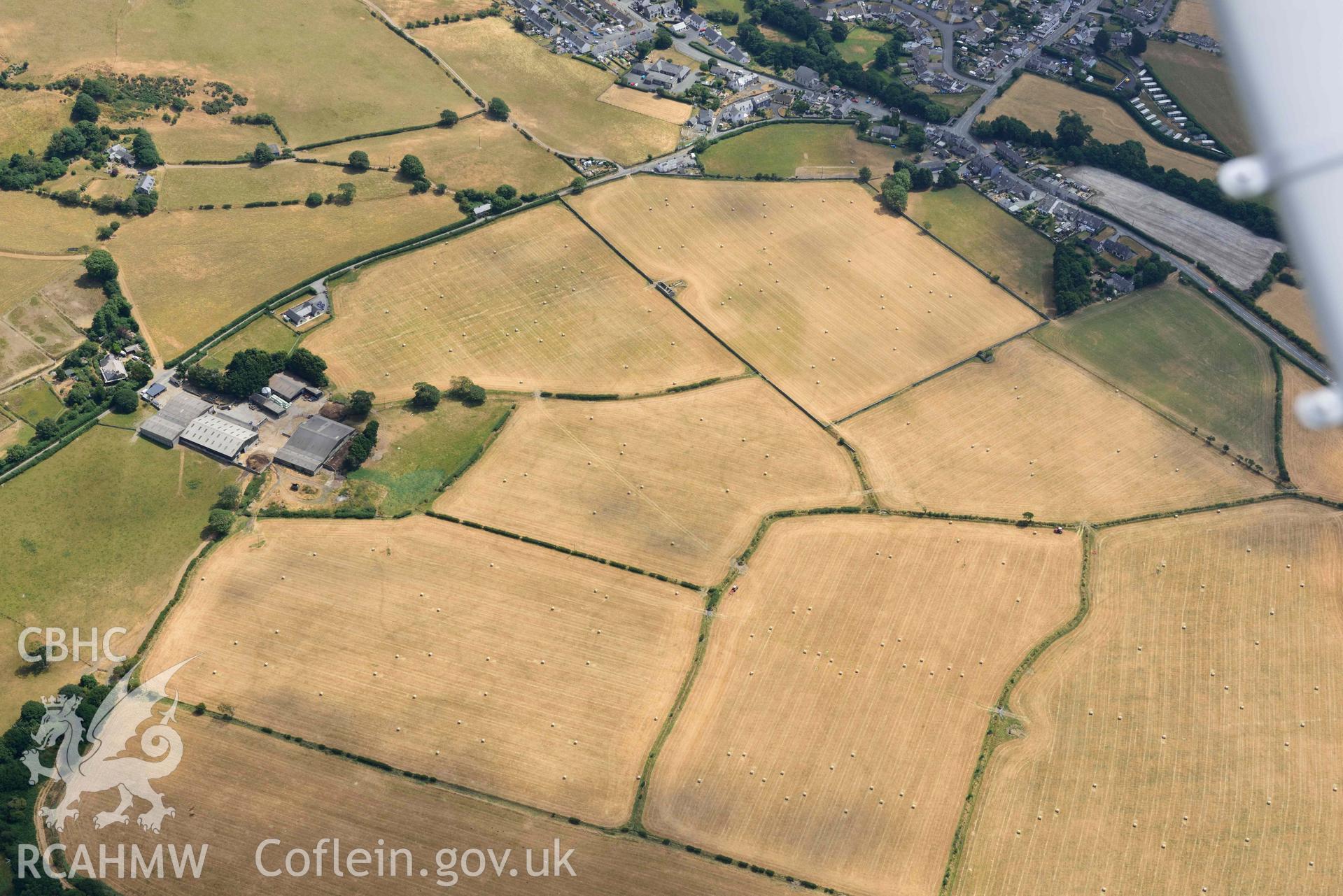 Enclosures to the west of Gwyddelfynydd, part of the Bryncrug cropmarks complex. Oblique aerial photograph taken during the Royal Commission’s programme of archaeological aerial reconnaissance by Toby Driver on 10 July 2018.