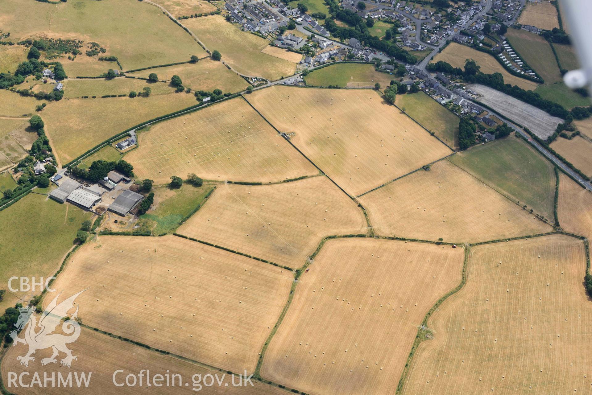 Enclosures to the west of Gwyddelfynydd, part of the Bryncrug cropmarks complex. Oblique aerial photograph taken during the Royal Commission’s programme of archaeological aerial reconnaissance by Toby Driver on 10 July 2018.